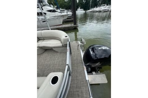 2023 Cypress Cay Seabreeze 232 pontoon boat docked with outboard motor.