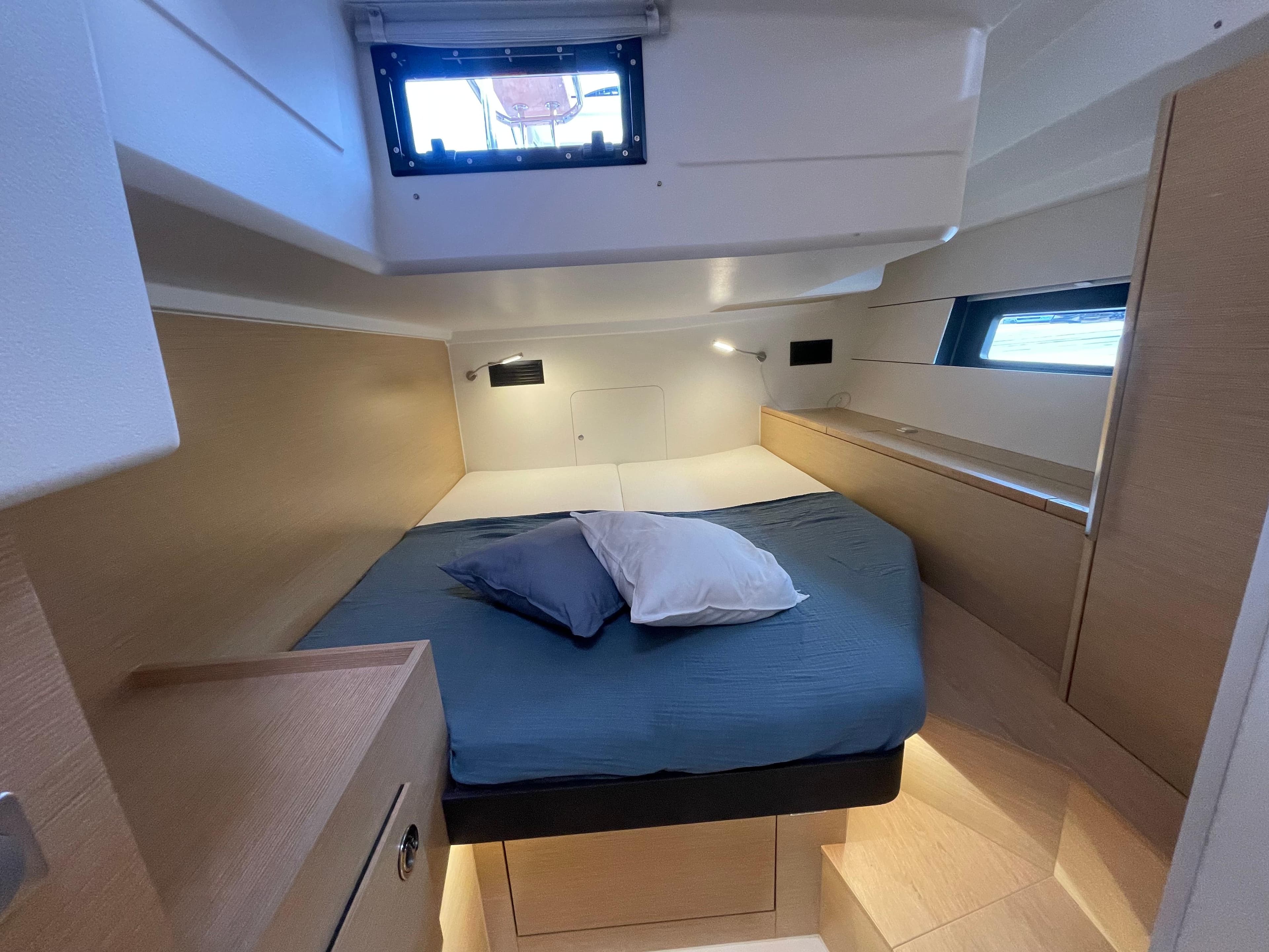 Cozy cabin interior of 2023 Hanse 460 yacht with modern design and comfortable bedding.