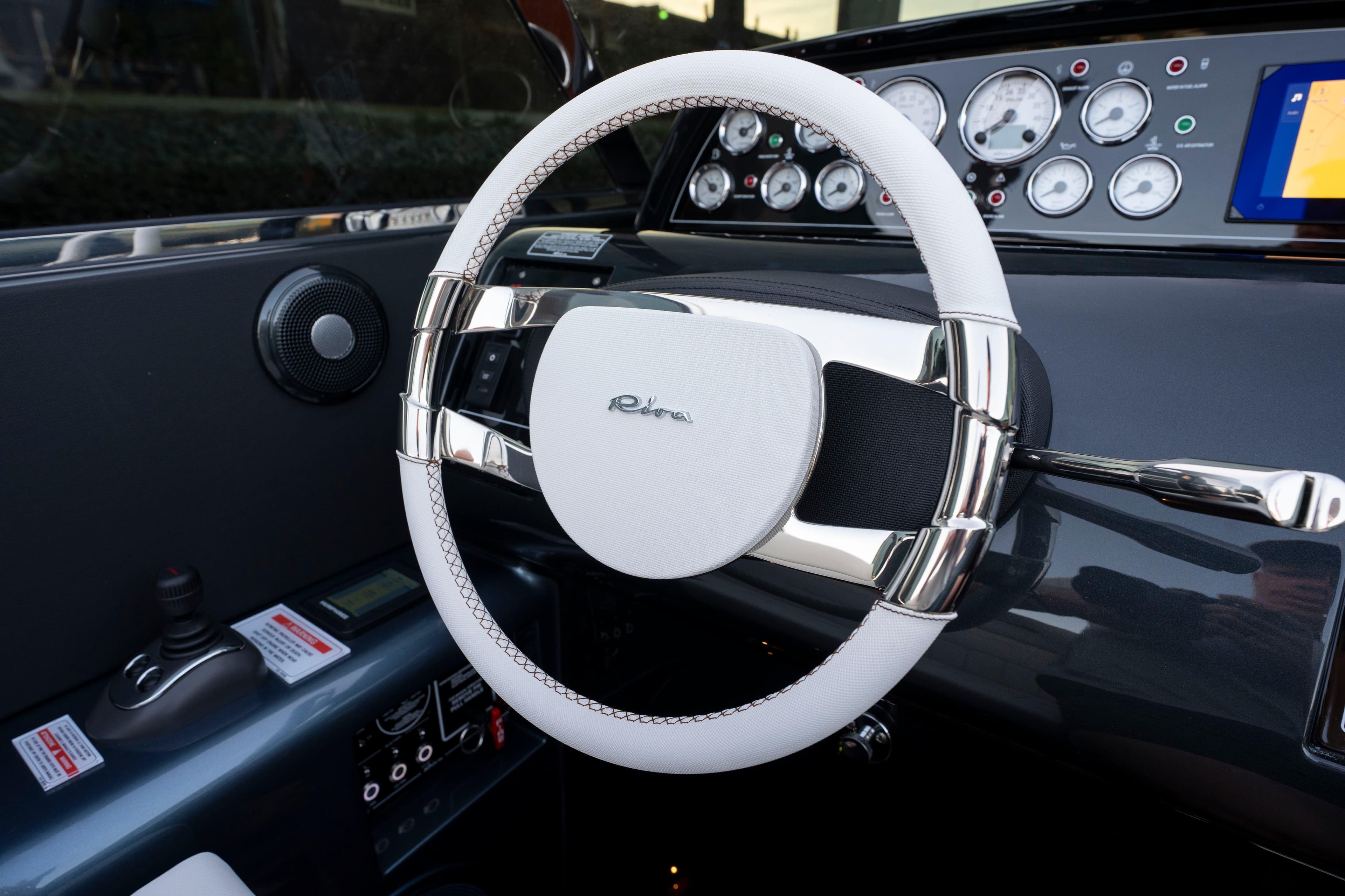 Steering wheel of 2026 Riva 33' Aquariva Special with sleek dashboard design.