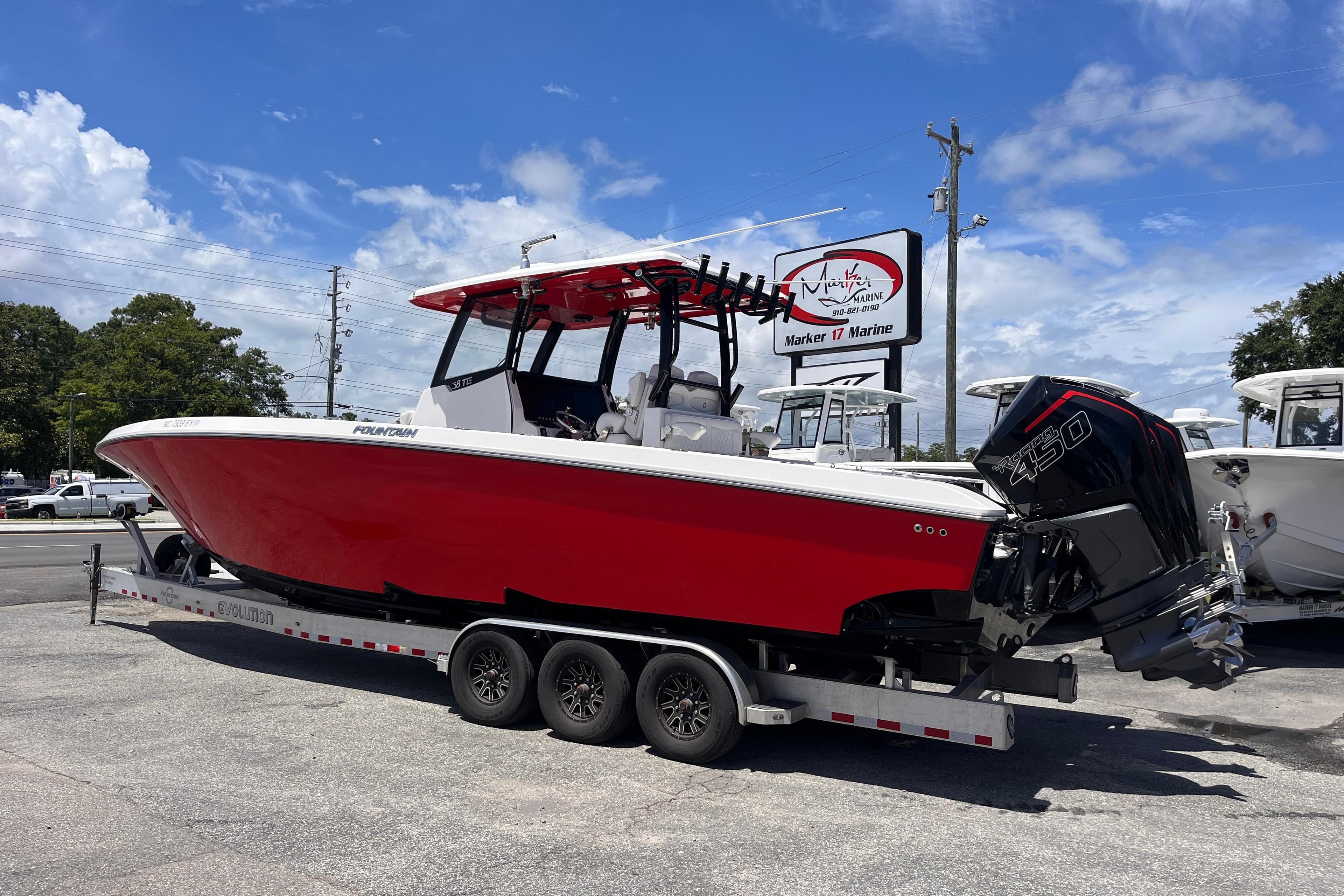 2023 Fountain 38 Tournament Edition boat on trailer, red hull, parked outdoors.