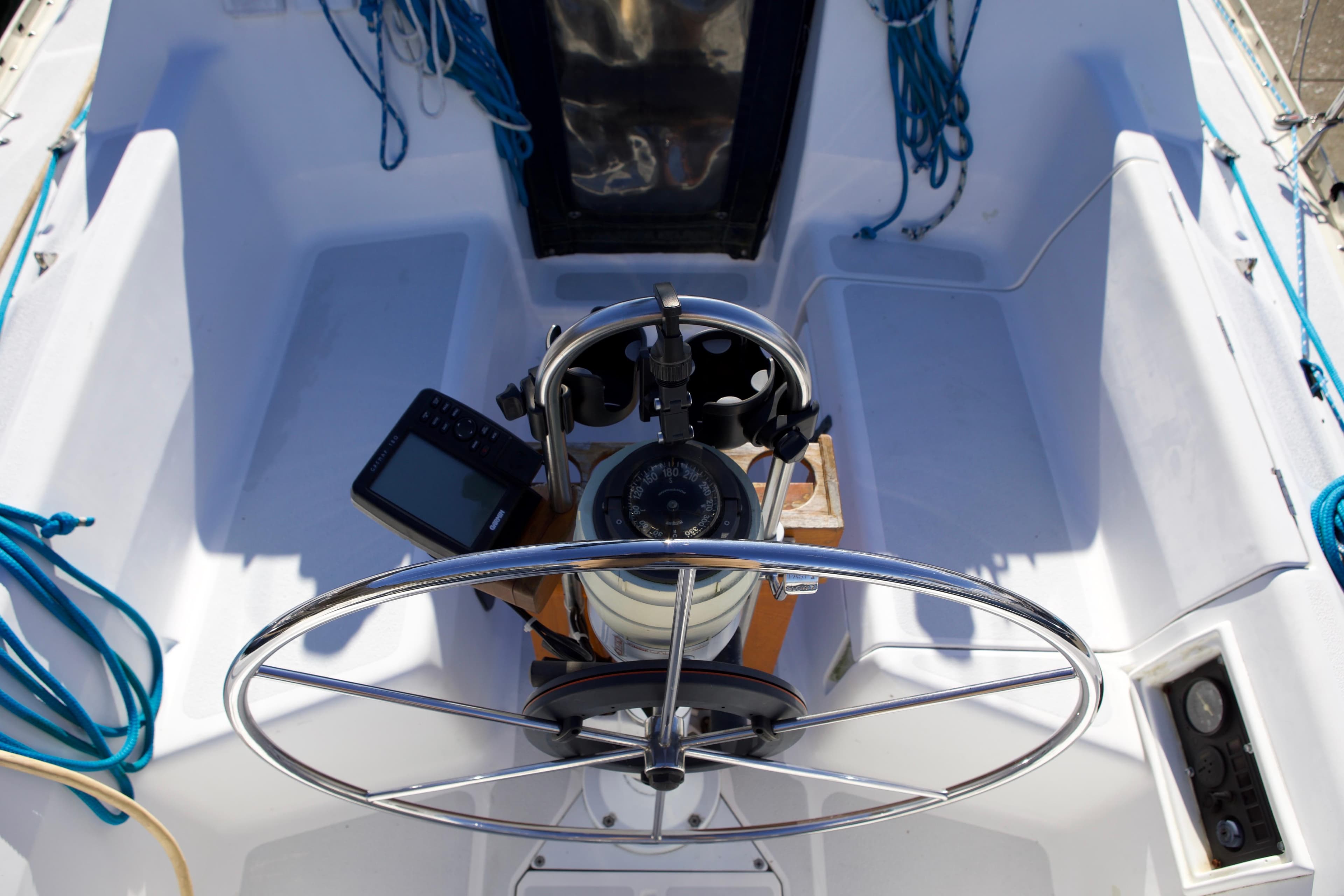 Cockpit of 1992 Hunter 33.5 sailboat with steering wheel and navigation equipment.