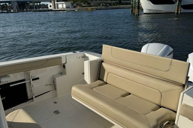 2020 Pursuit S 328 Sport boat interior with beige seating, docked by the water.