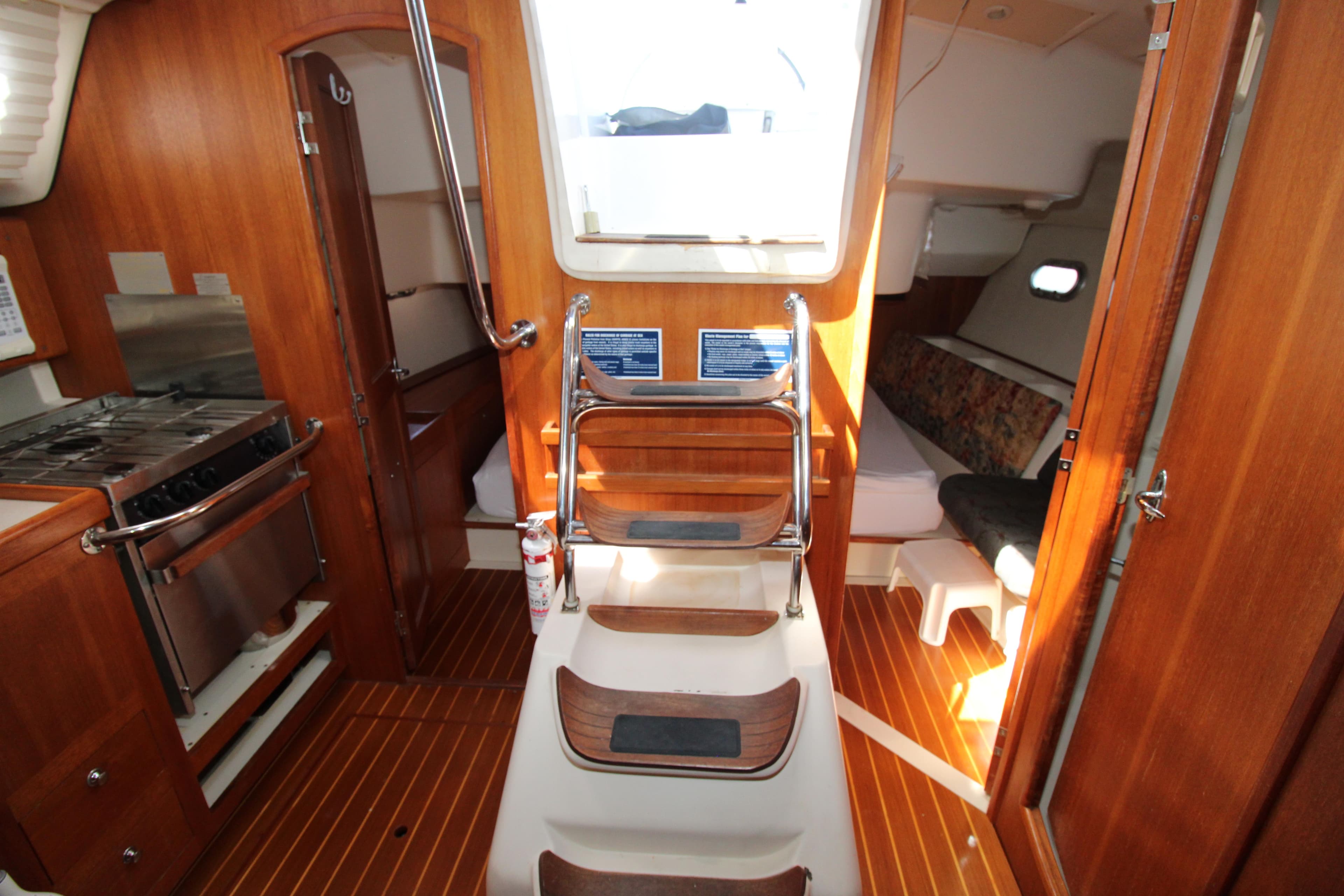 Interior of 2002 Hunter 410 sailboat with wood finish and compact kitchen area.
