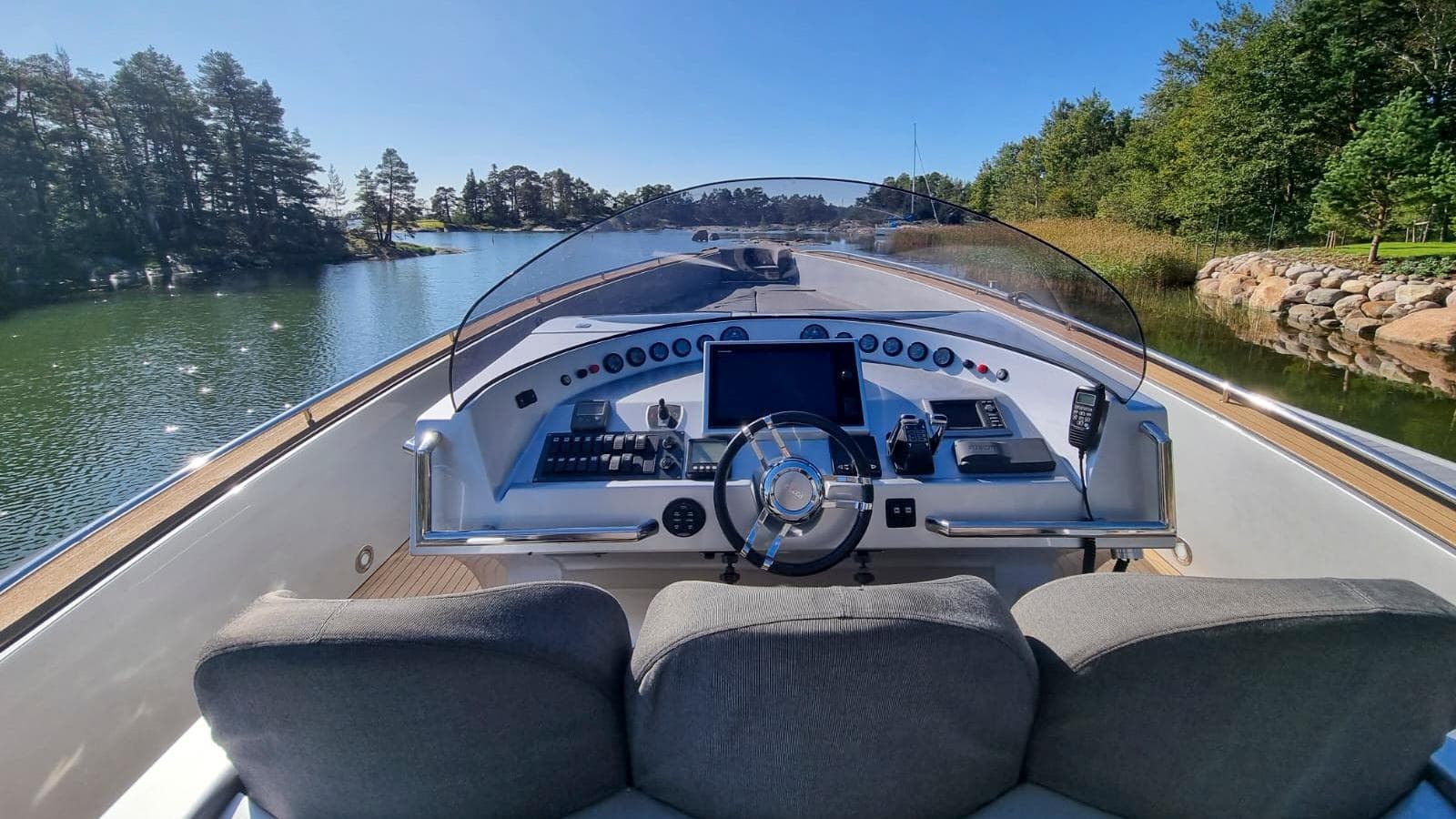 Helm of 2008 Custom Cantieri Opera 60 yacht cruising on a scenic waterway.