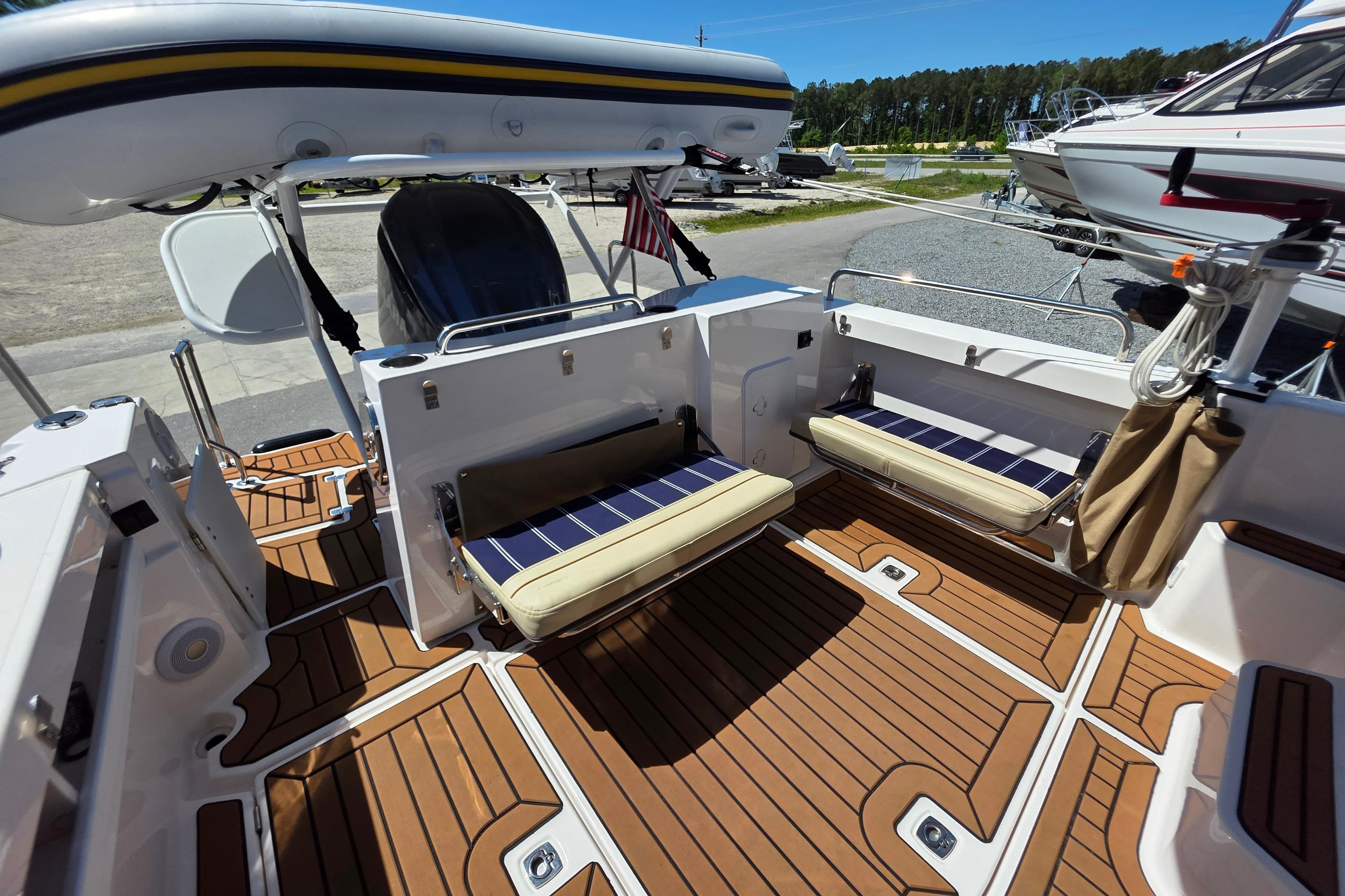 2025 Ranger Tugs R-25 boat interior with foldable seating and teak flooring.