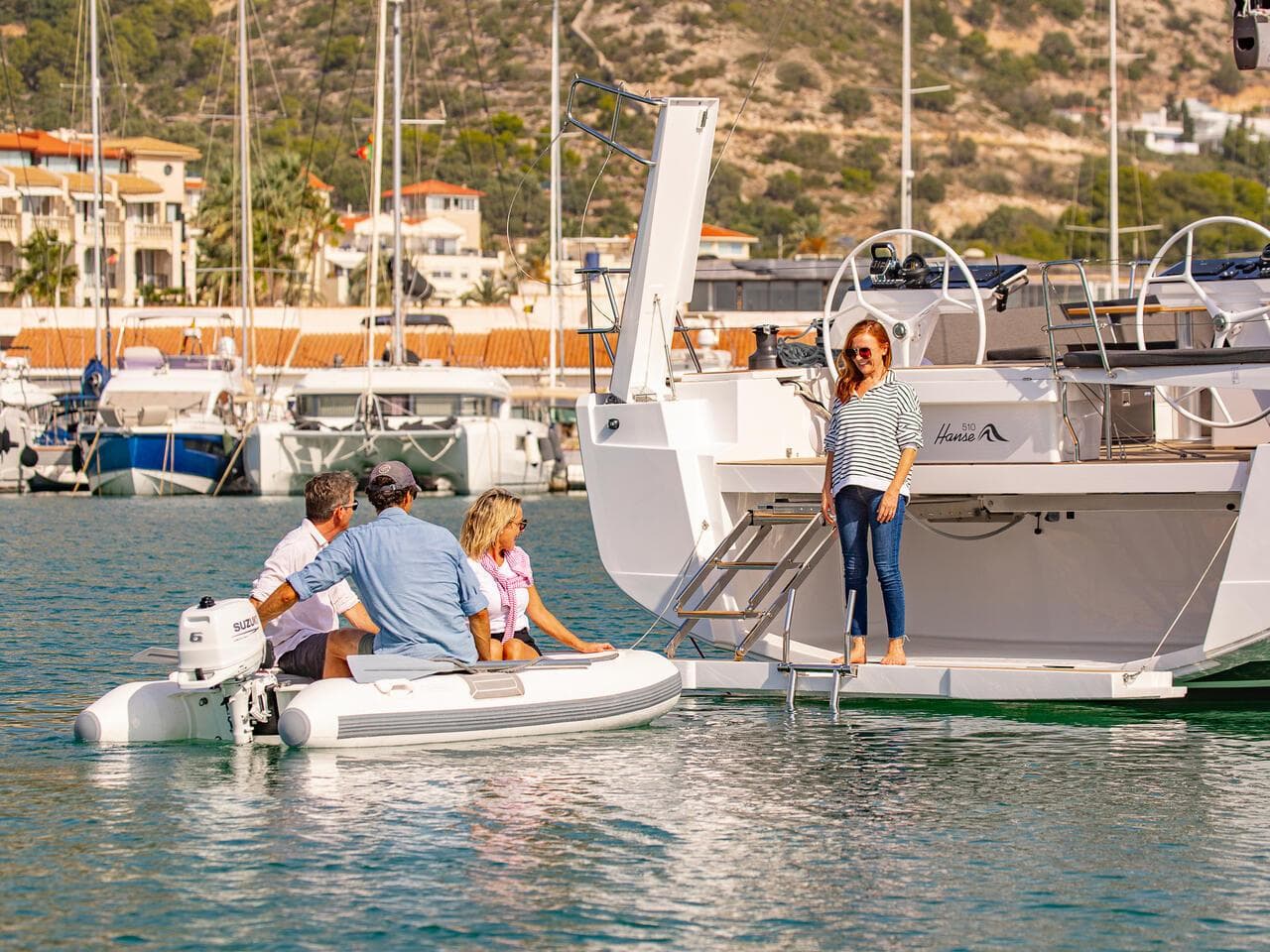 People enjoying a day on a 2025 Hanse 510 yacht, docked at a marina.