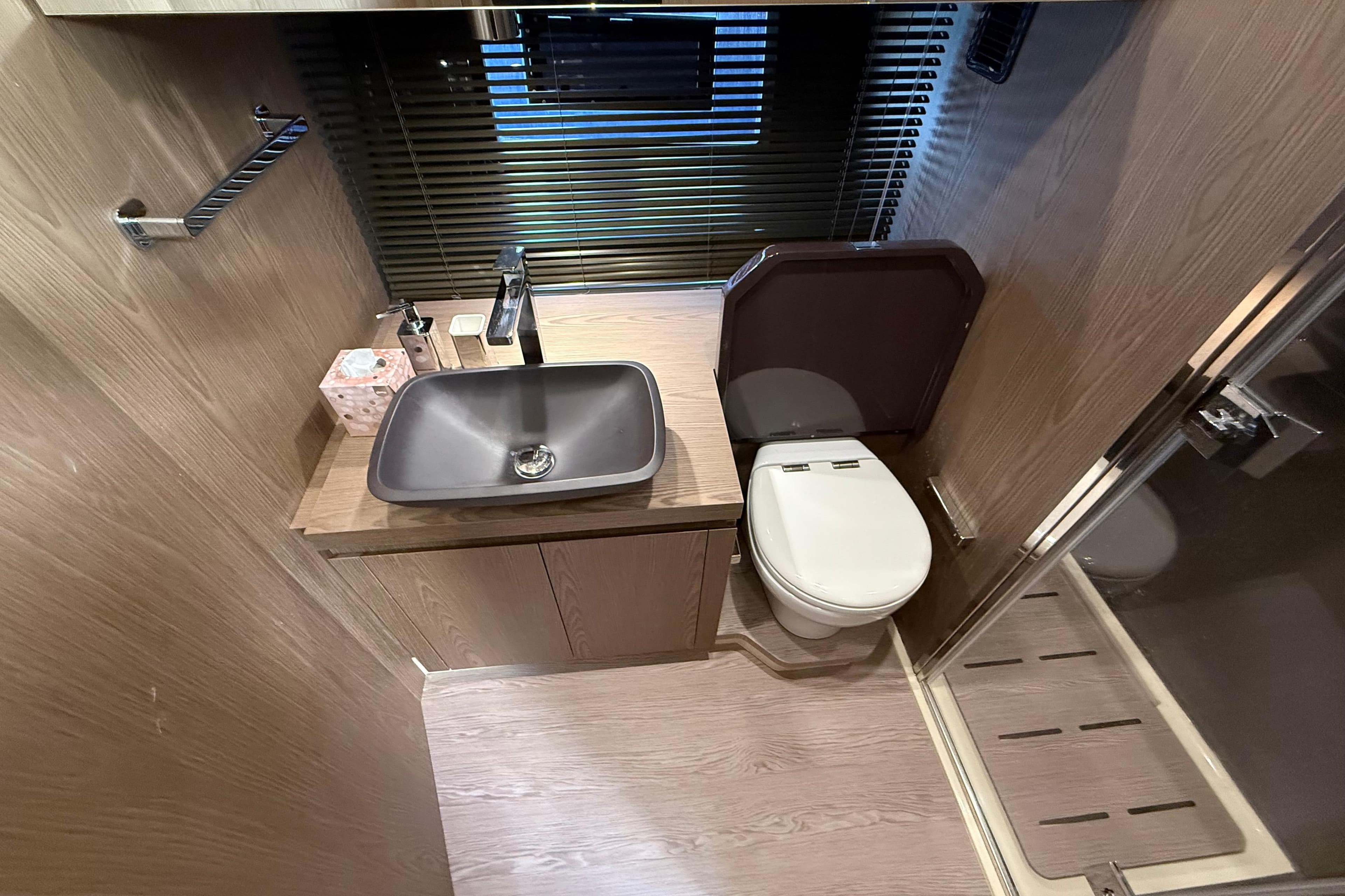 Modern bathroom interior of 2022 Invictus TT 460 yacht with sleek fixtures and wooden accents.