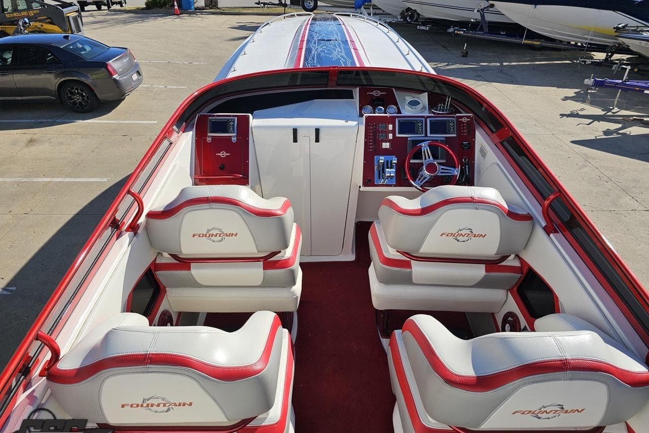 2009 Fountain 47 Lightning boat interior with red and white seating and control panel.