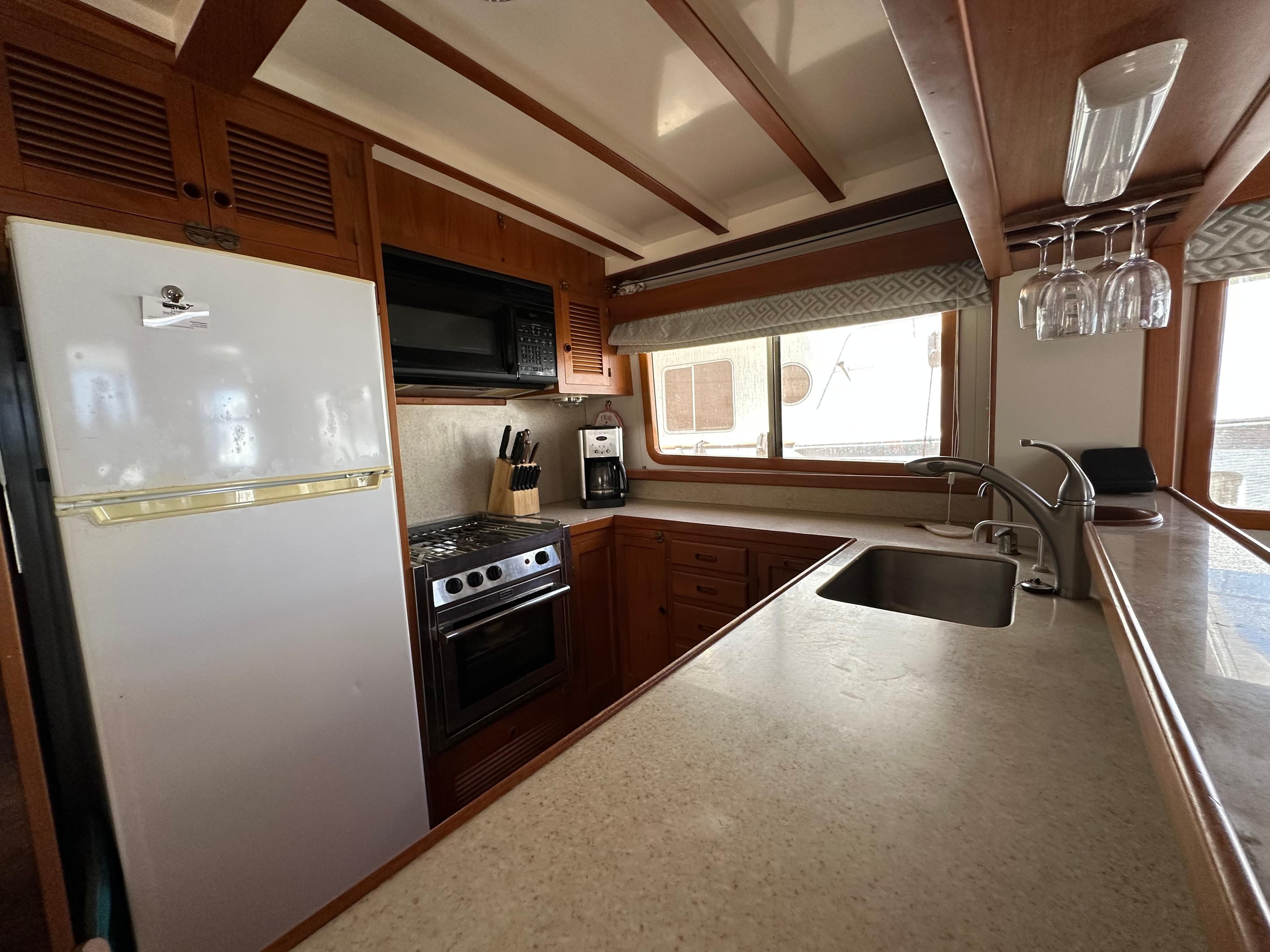 Kadey-Krogen 48 Whaleback 1997 yacht kitchen with modern appliances and wooden cabinetry.
