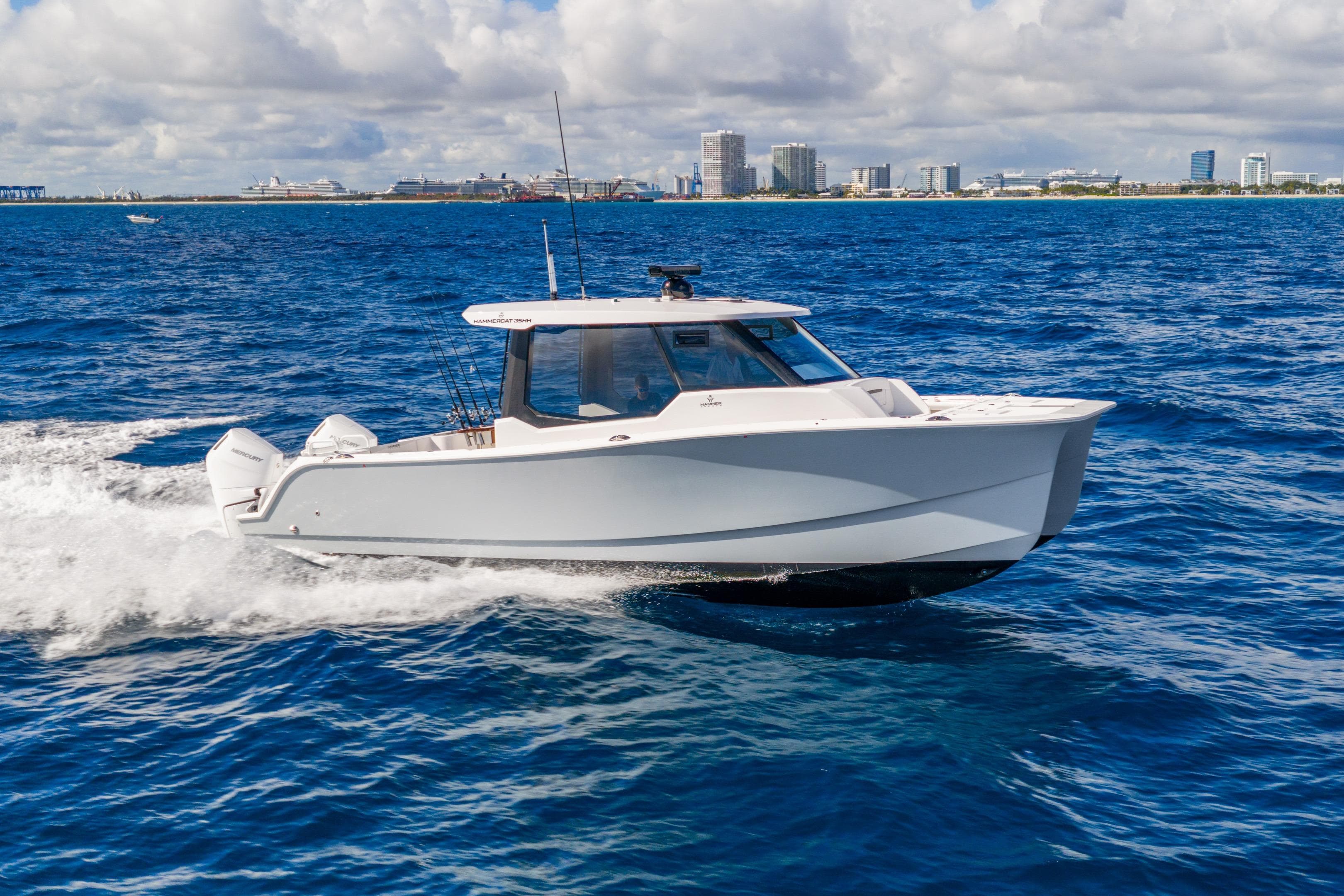 2026 Hammer Yachts 35HH cruising on blue ocean near city skyline.