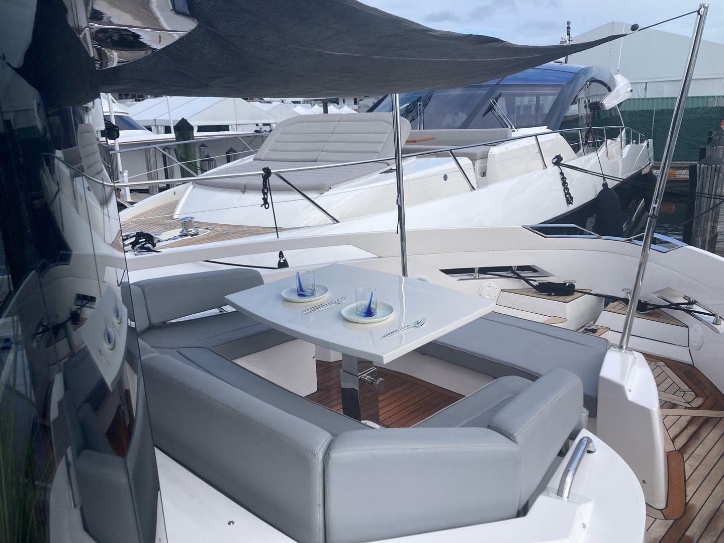 Luxurious 2024 OKEAN 52 yacht with elegant outdoor seating and dining area.