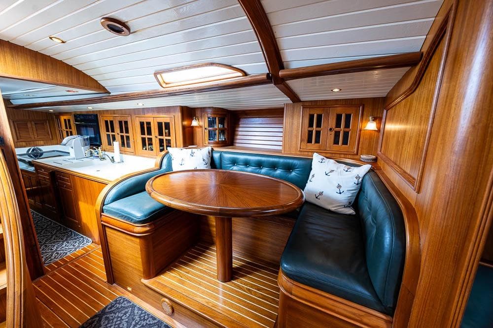 Luxurious 1974 C&C 61 Ocean Racer interior with wood finish and cozy seating area.