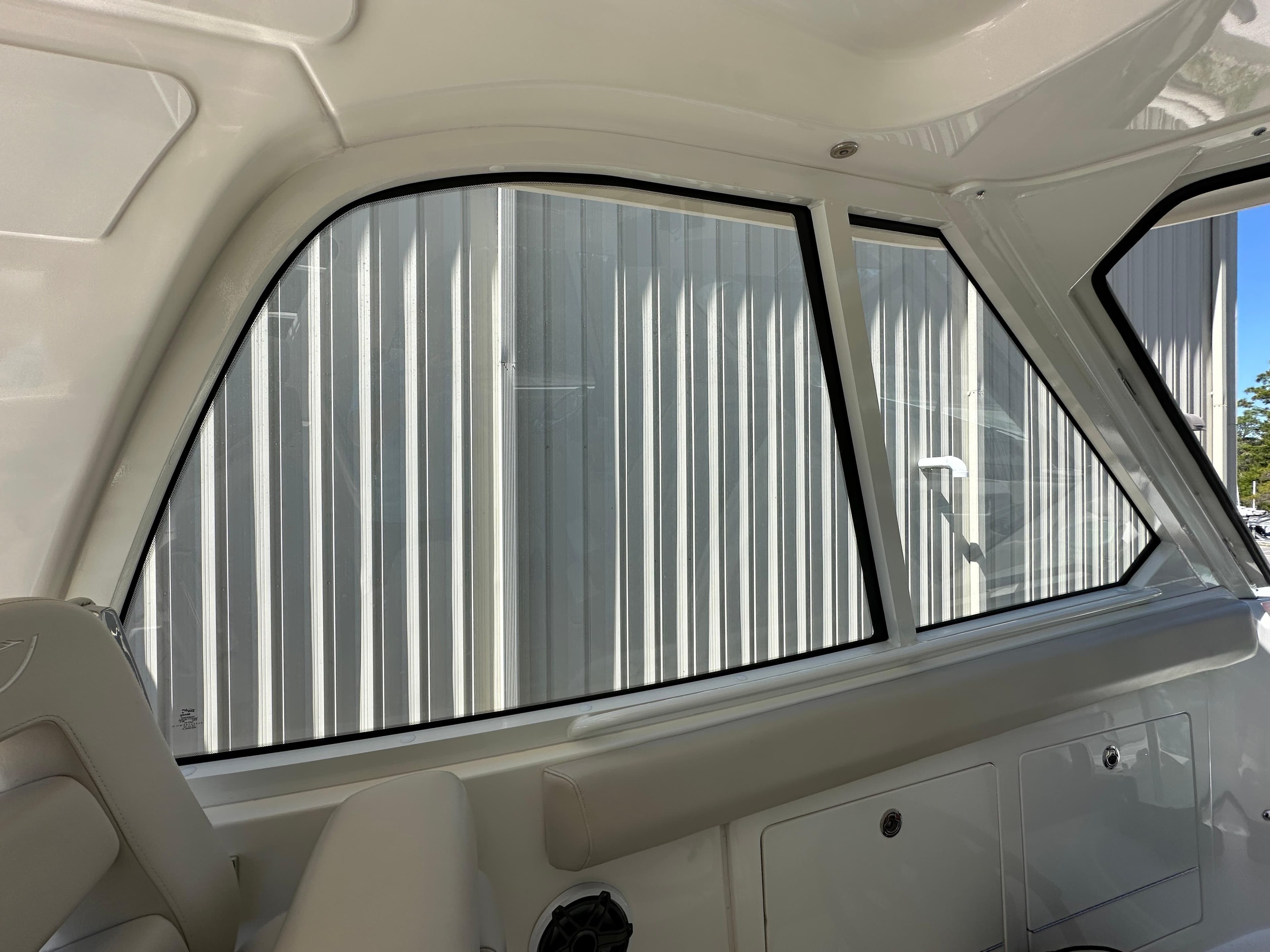Interior view of 2021 Boston Whaler Realm 380 boat, showcasing window and seating area.