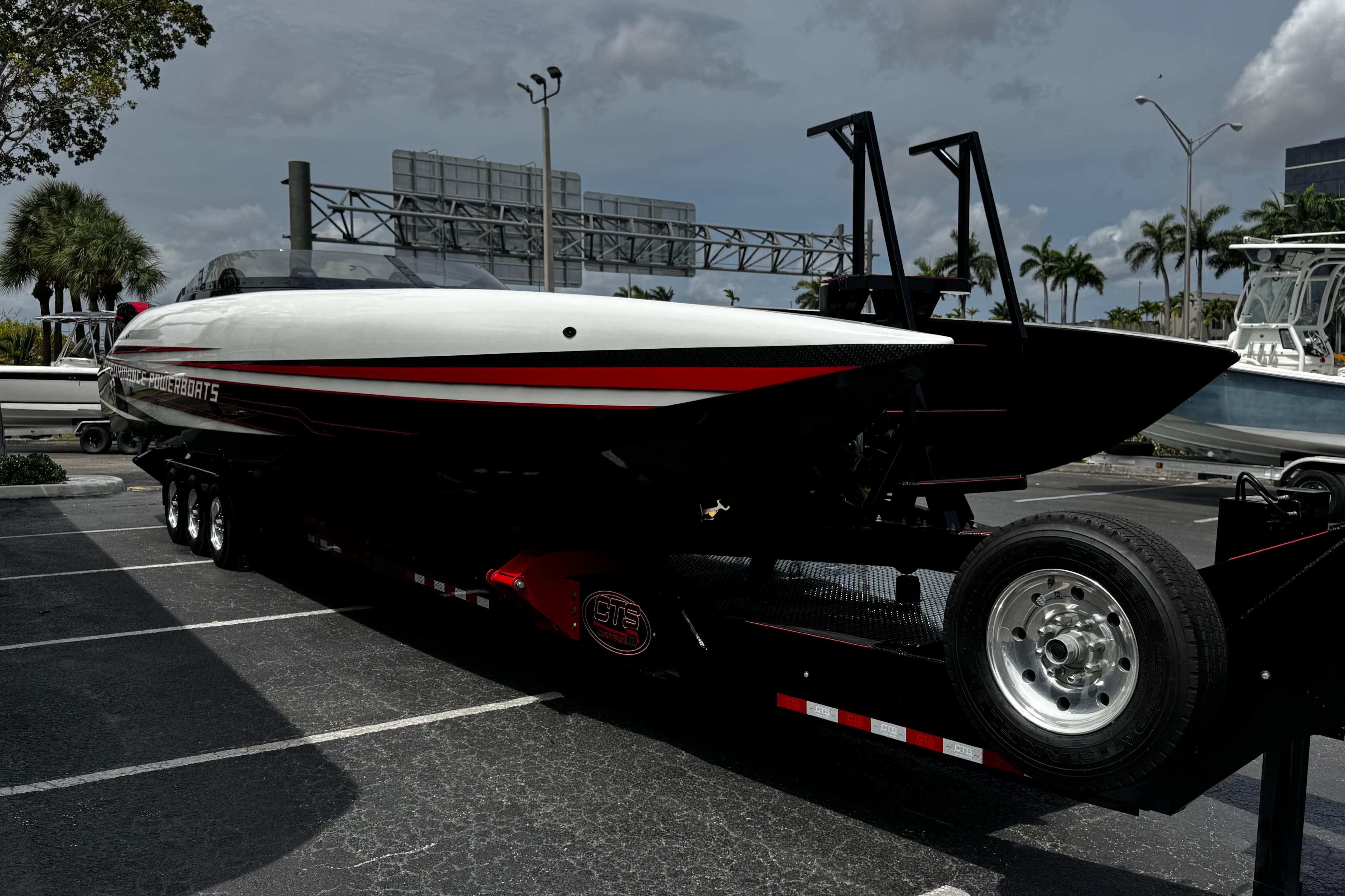 2025 Performance Powerboats P420 on trailer, sleek design, parked outdoors under cloudy sky.