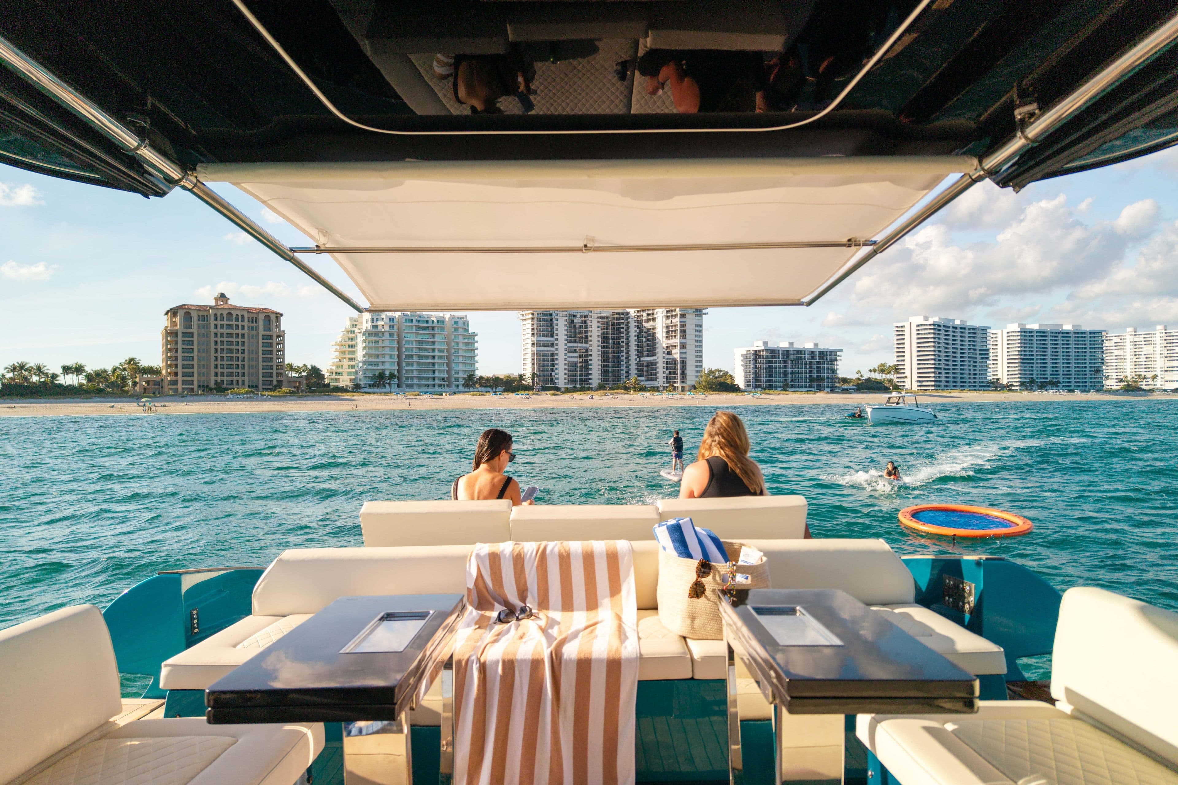 2024 Solaris Power 52 Open yacht with beach view, people relaxing onboard.