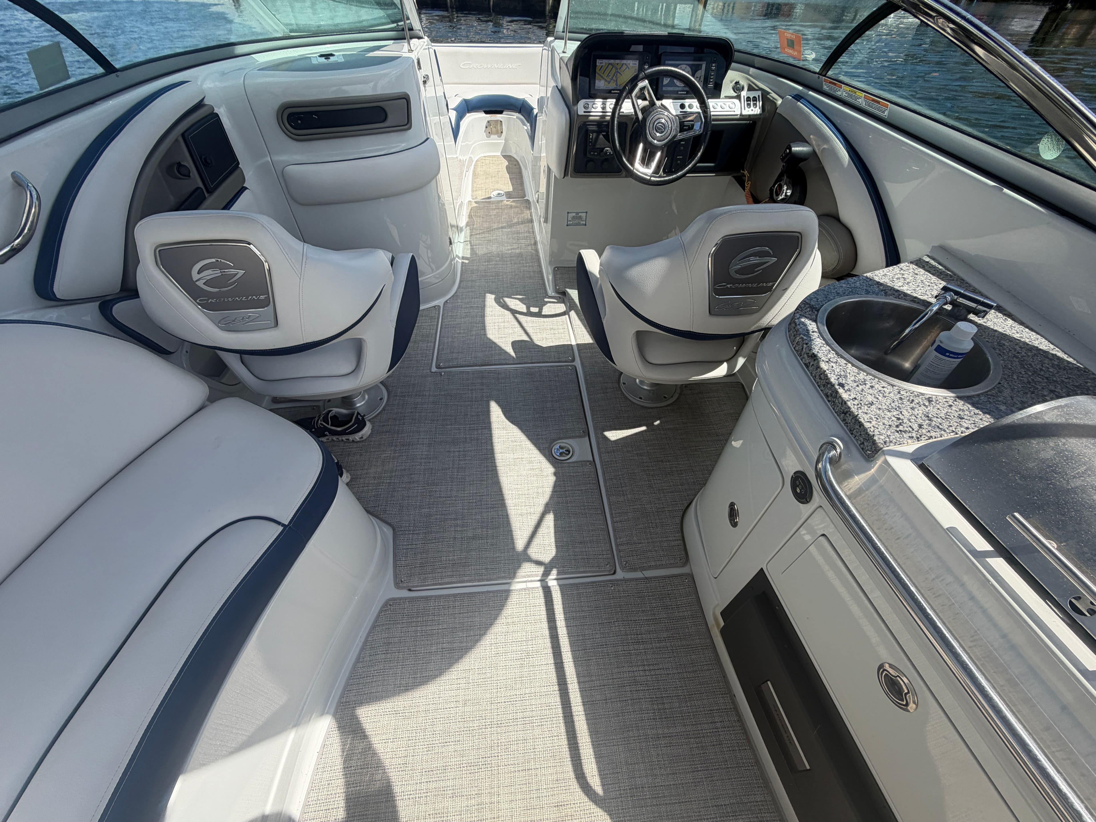 Interior of 2023 Crownline Eclipse E285 XS boat with steering wheel and seating area.