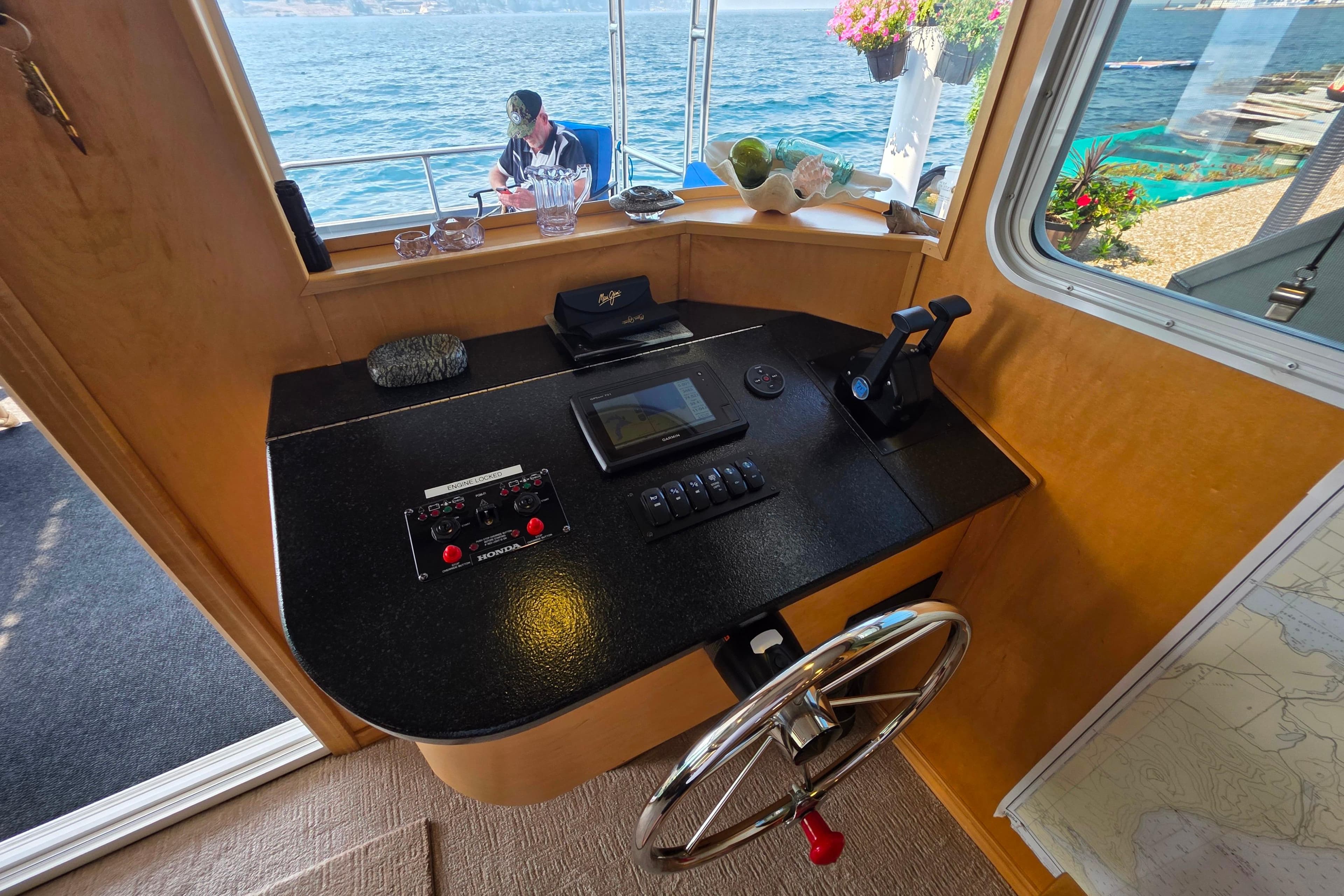 Pilothouse of 2015 Sailabration 64 boat with steering wheel, control panel, and ocean view.