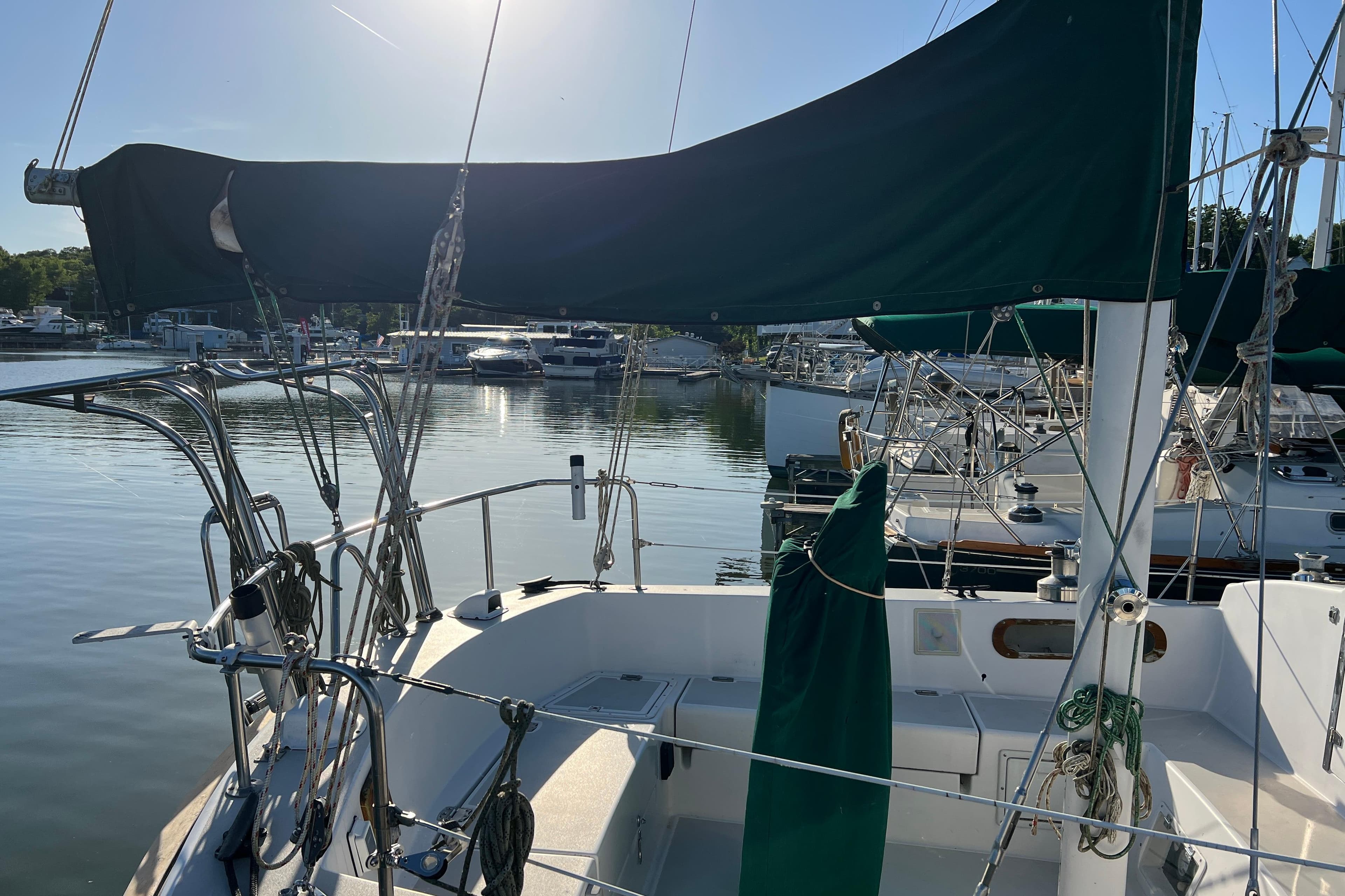 Sailboat docked at marina, Pearson 424 model, 1979, with green sail cover.