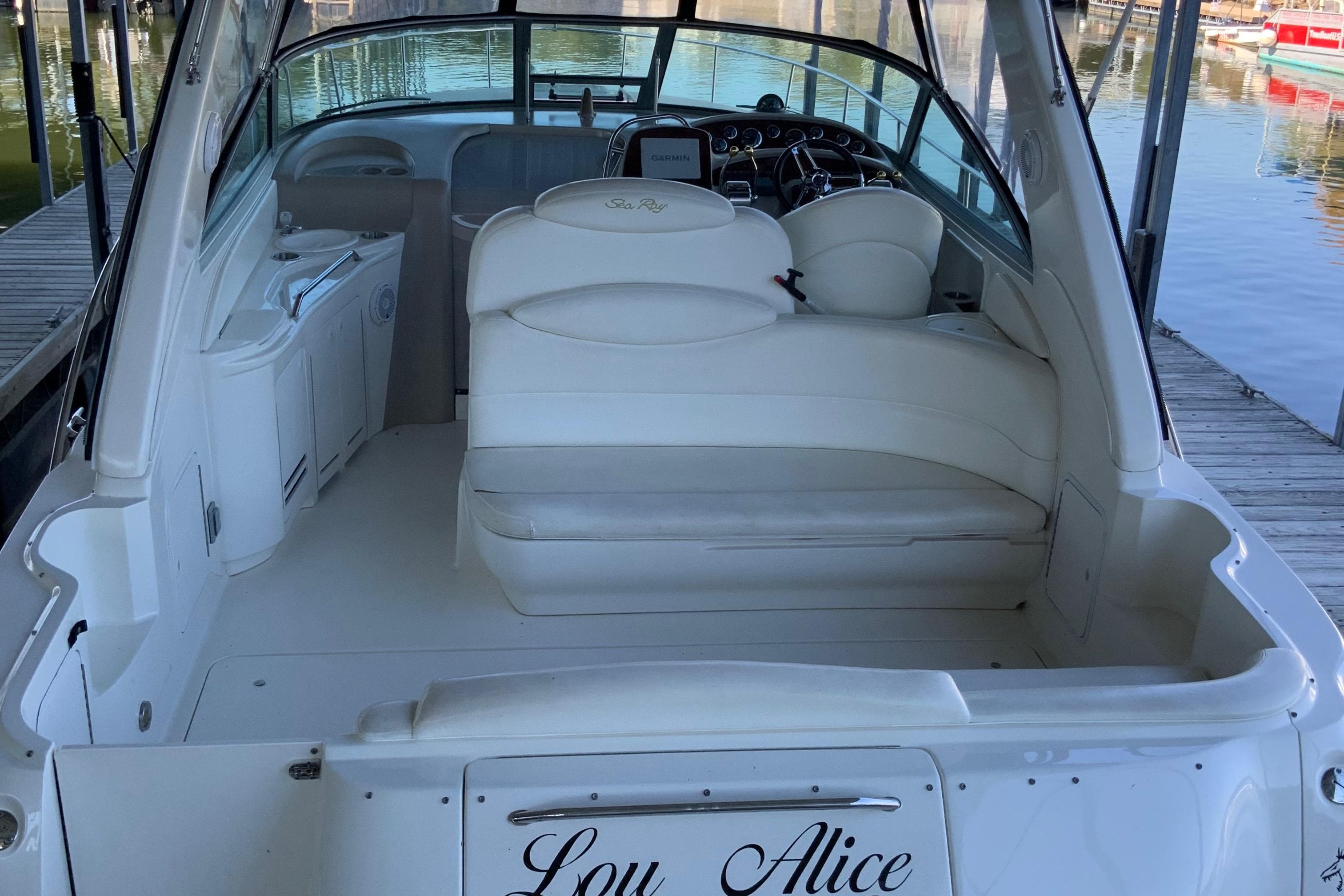 2000 Sea Ray Sundancer boat interior with white seating and helm, docked by the water.