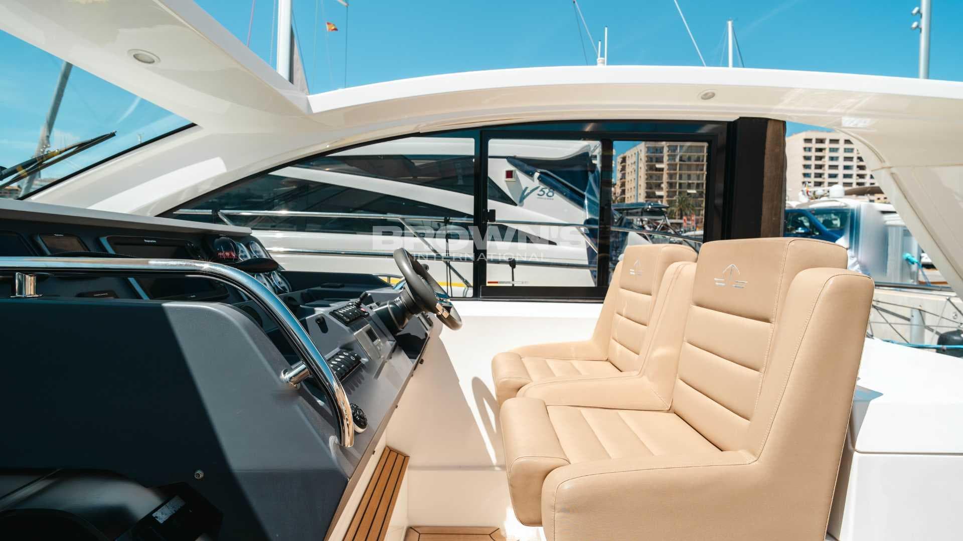2012 Sealine SC42 yacht interior with beige seats and modern dashboard.