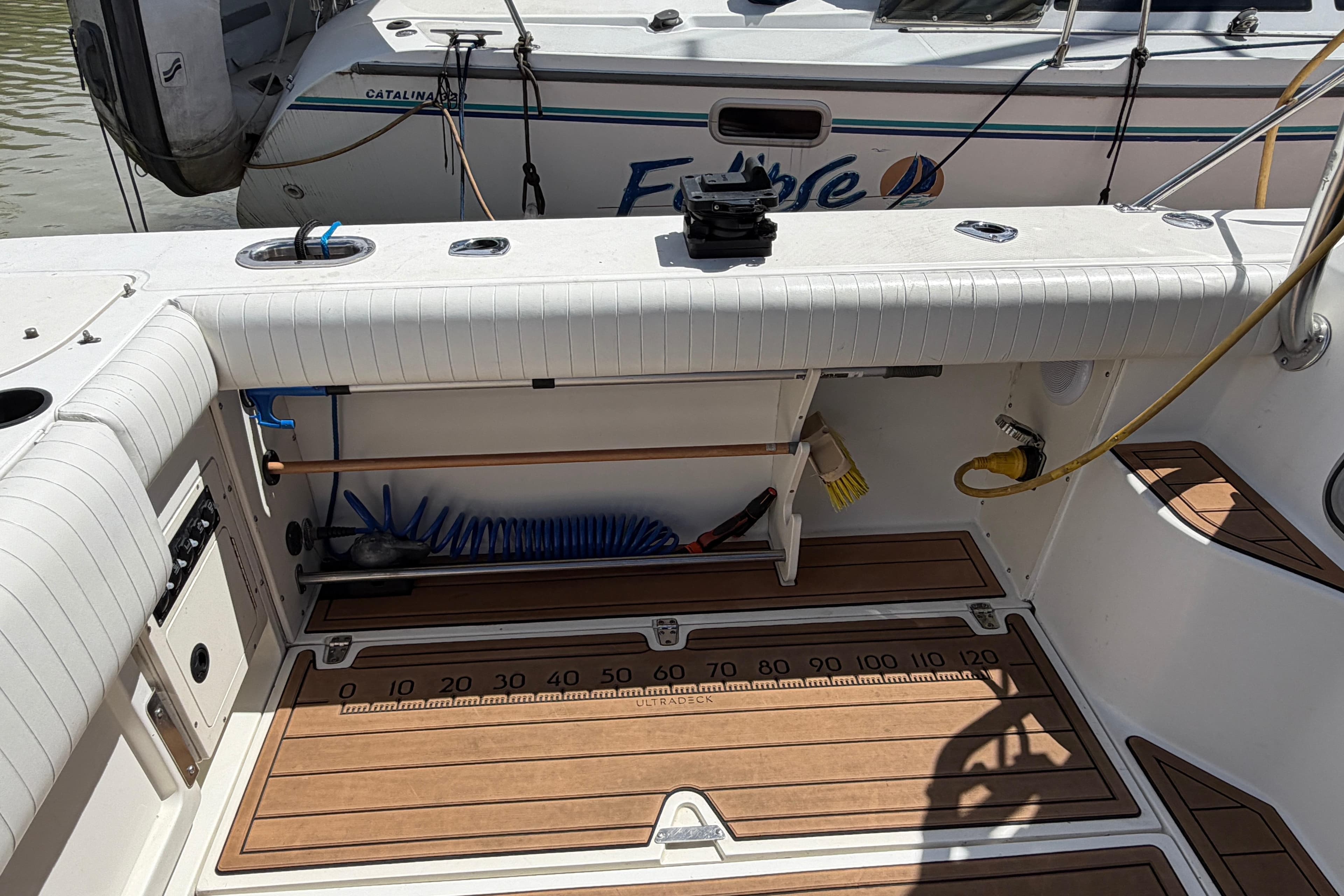 1999 Boston Whaler 28 Conquest boat interior with fishing equipment and teak flooring.