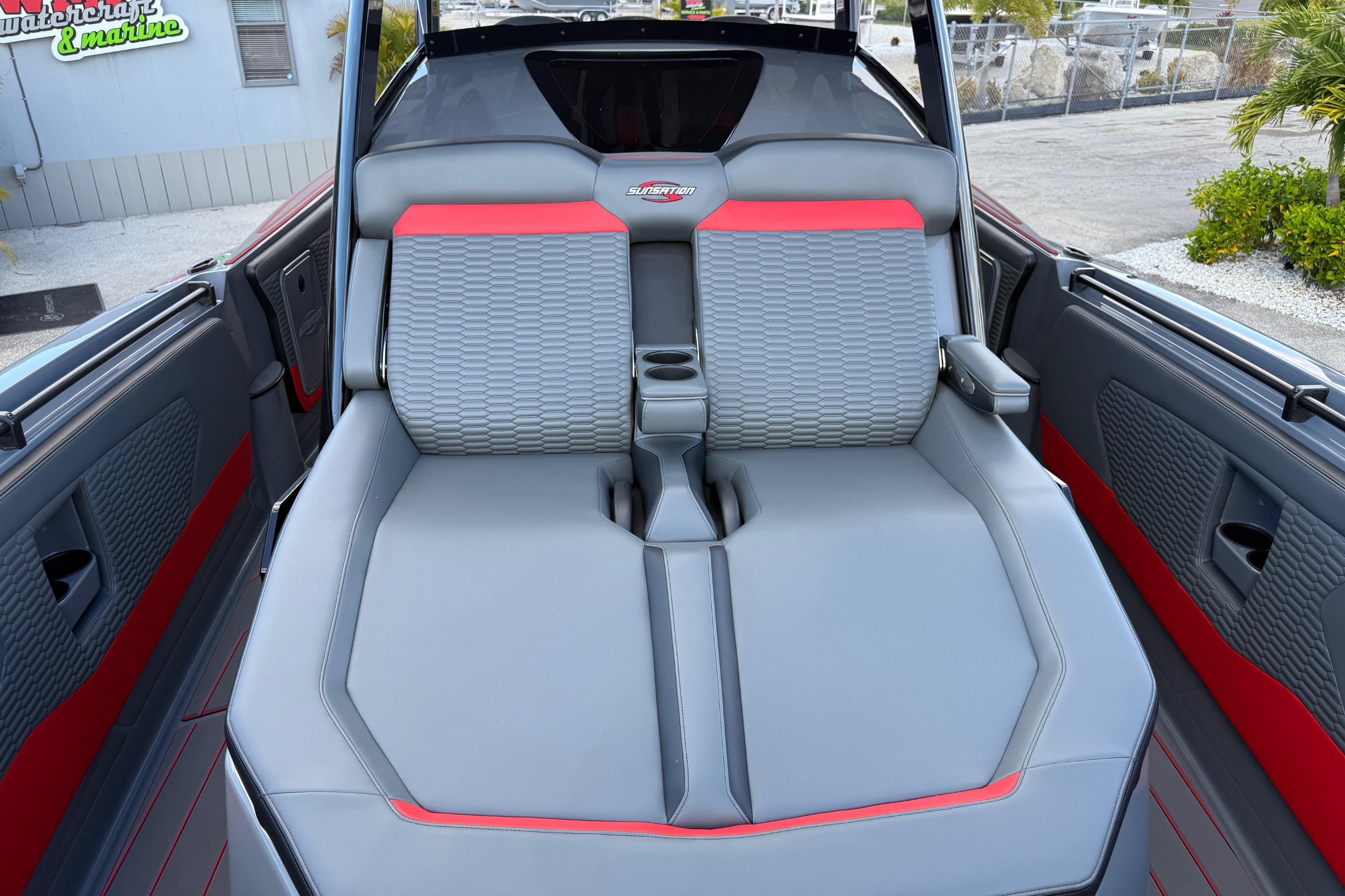 2026 Sunsation 34 CCX boat interior with gray and red seating, featuring cup holders.