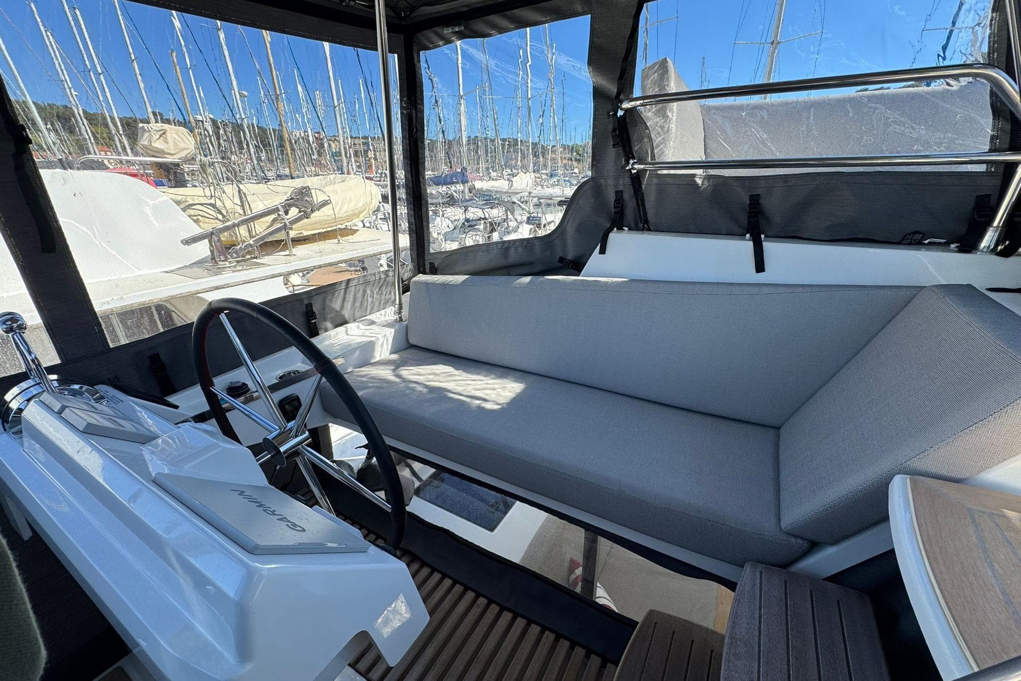 2025 Fountaine Pajot Tanna 47 yacht cockpit with steering wheel and cushioned seating.