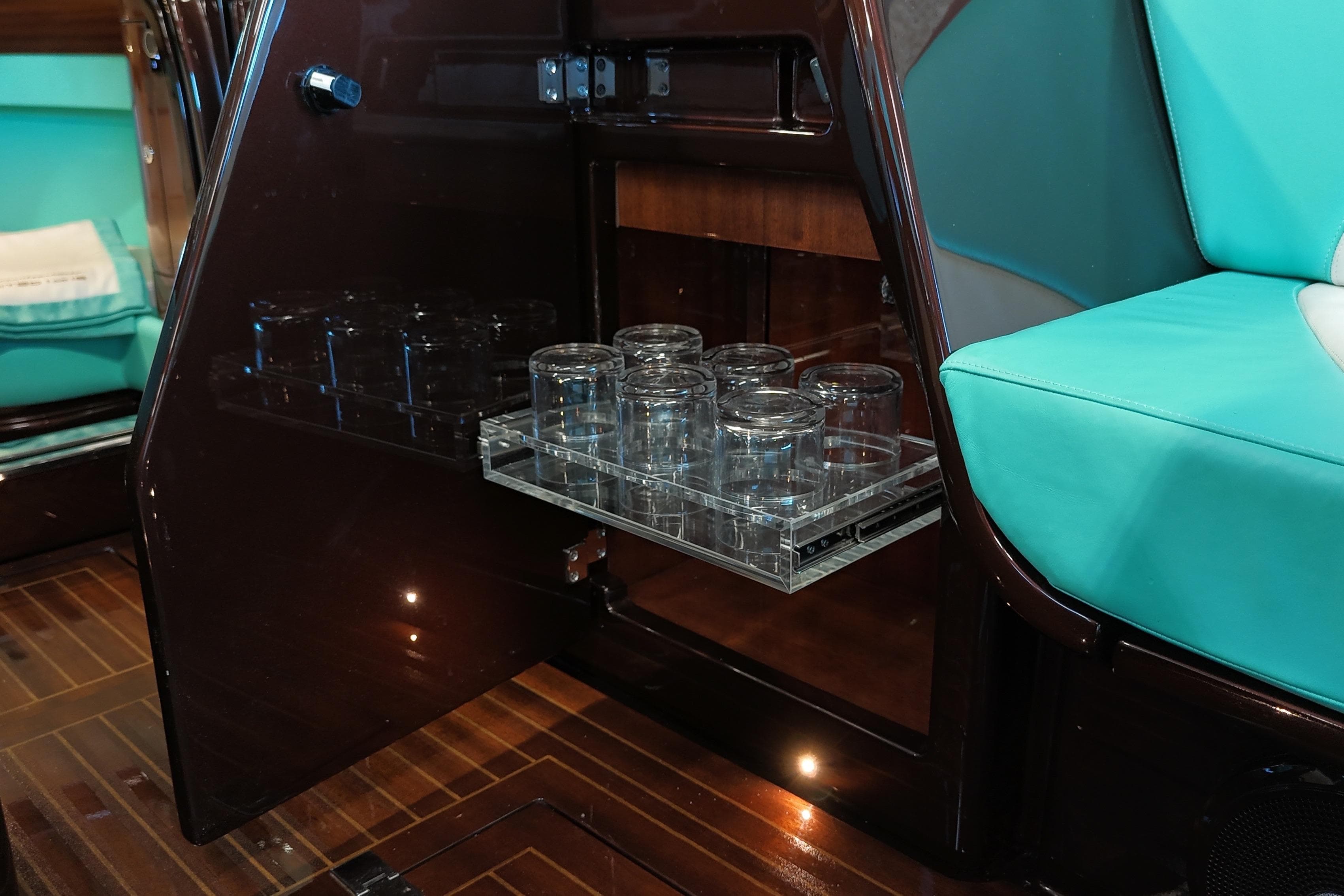 2024 Riva Anniversario yacht interior with glass storage and turquoise seating.