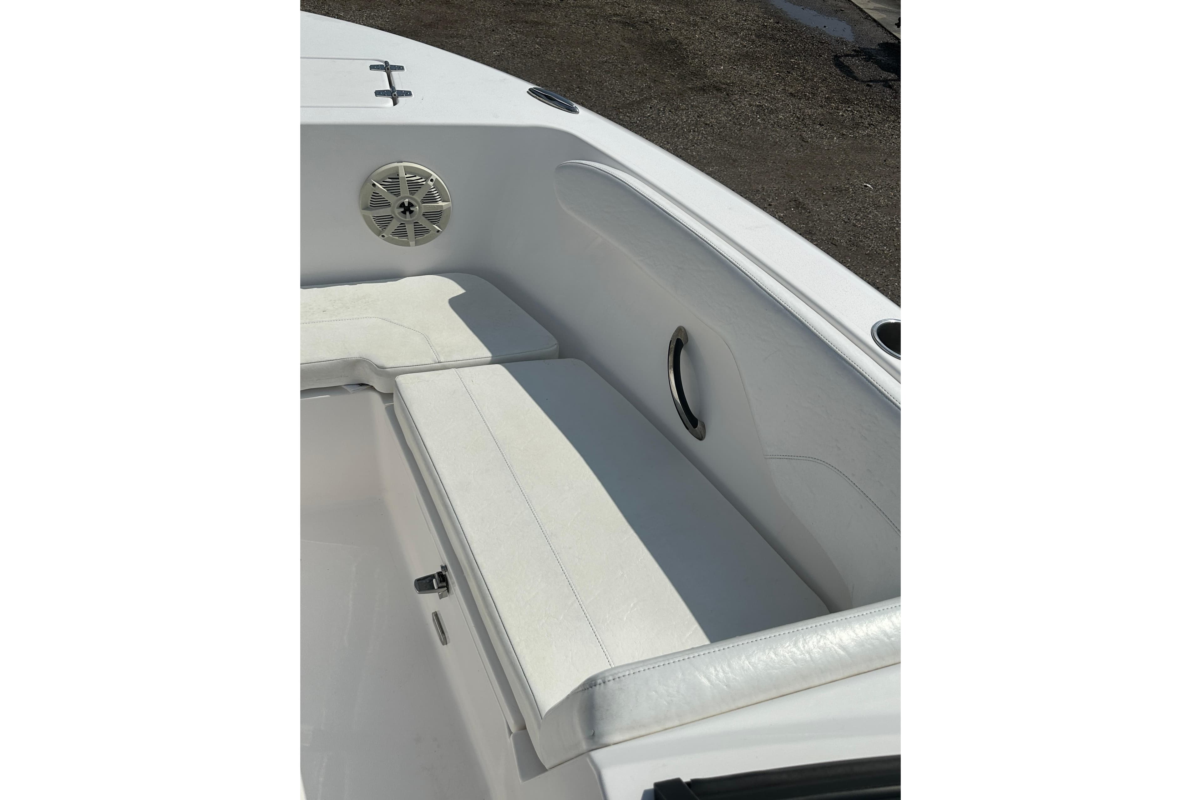 2024 Aquasport 2200 Dual Console boat interior with white seating and speaker.