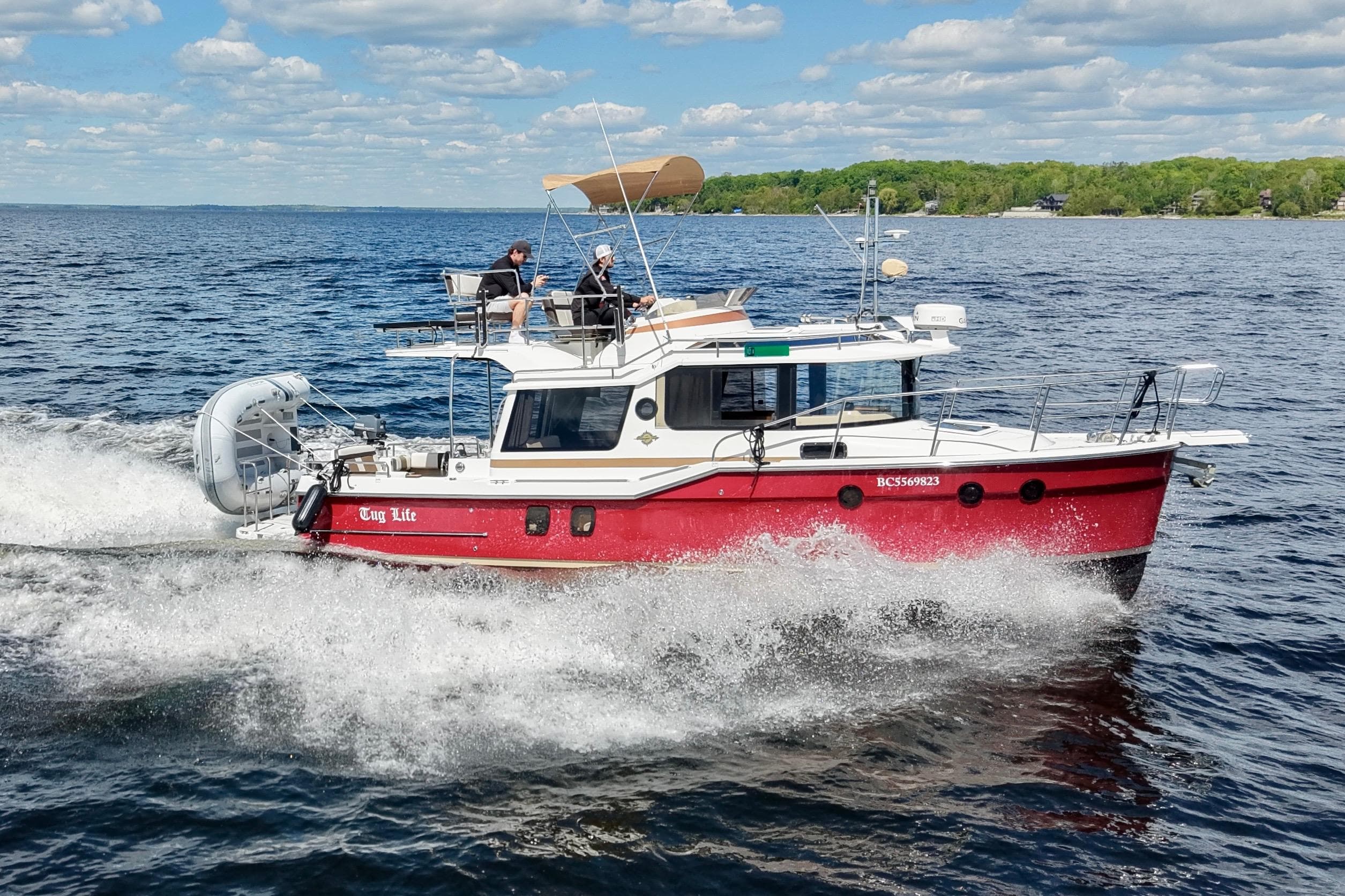 2017 Ranger Tugs R-29 CB cruising on a lake under a blue sky.