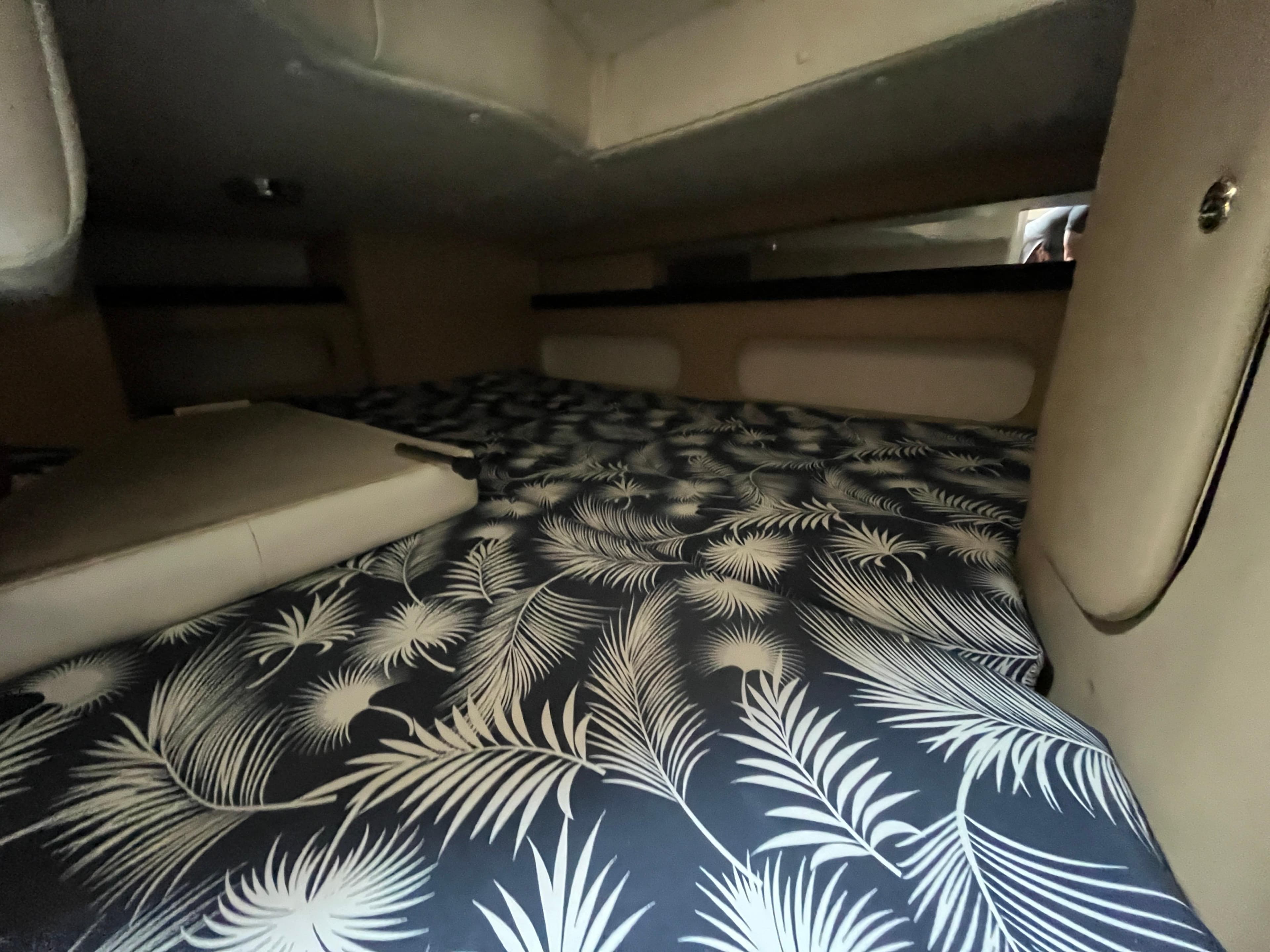 Interior cabin of 2004 Rinker Fiesta Vee 290 with patterned bedding.