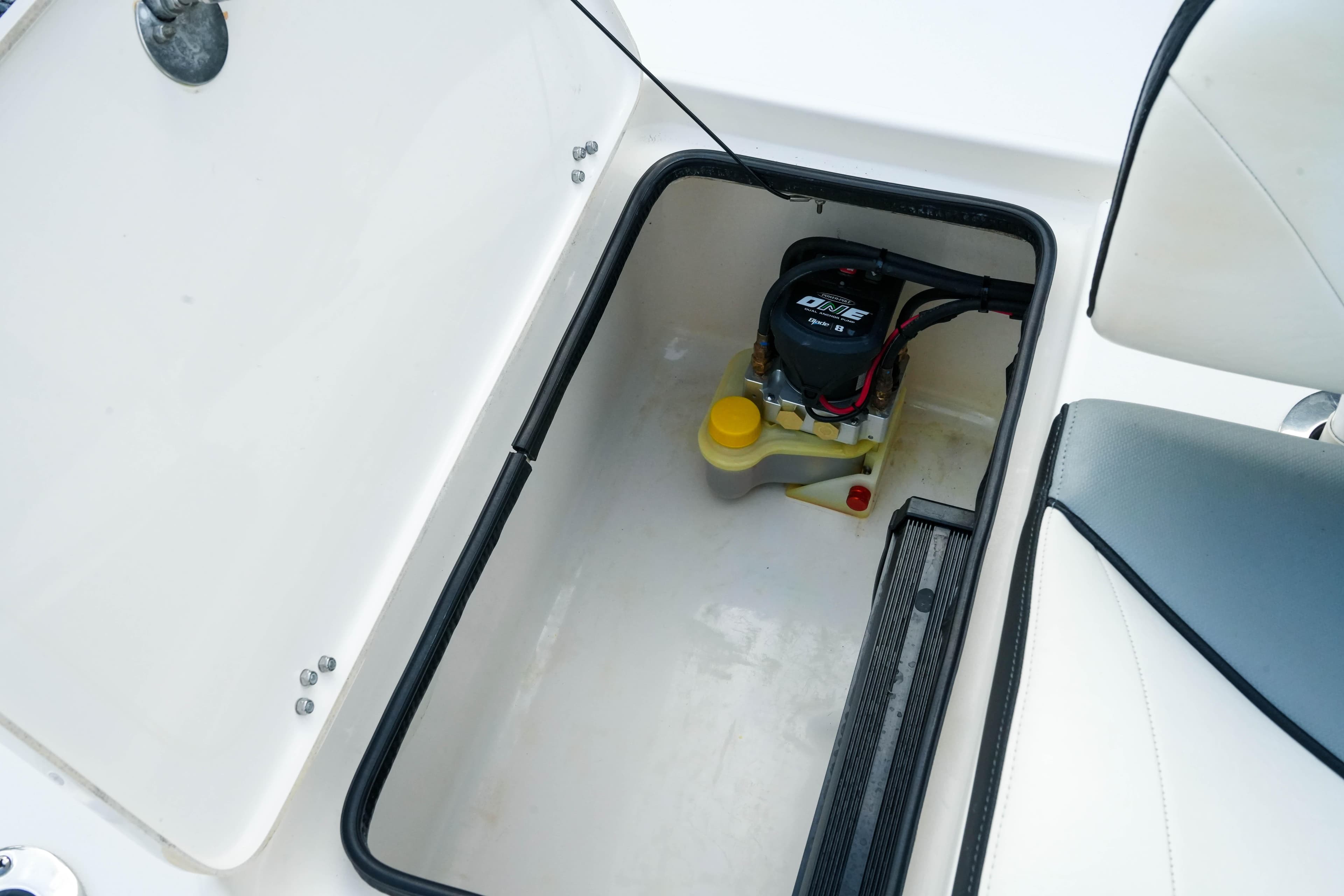 Storage compartment in a 2017 ShearWater x22 boat, featuring a battery and wiring.