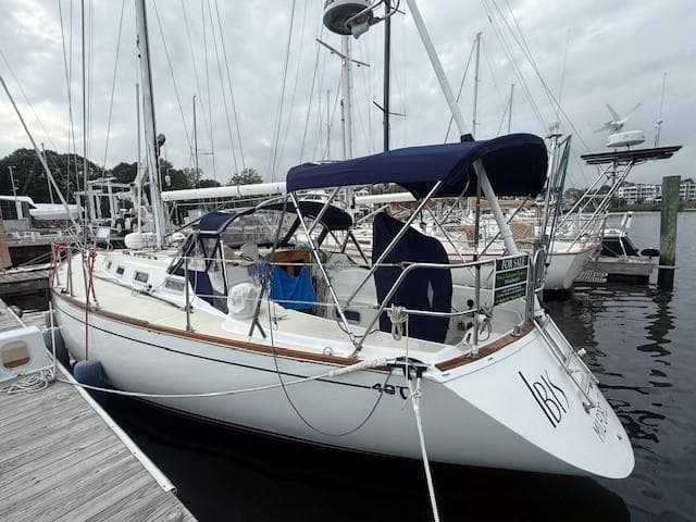 1987 Tartan 40CB sailboat docked, featuring blue canopy and sleek design.