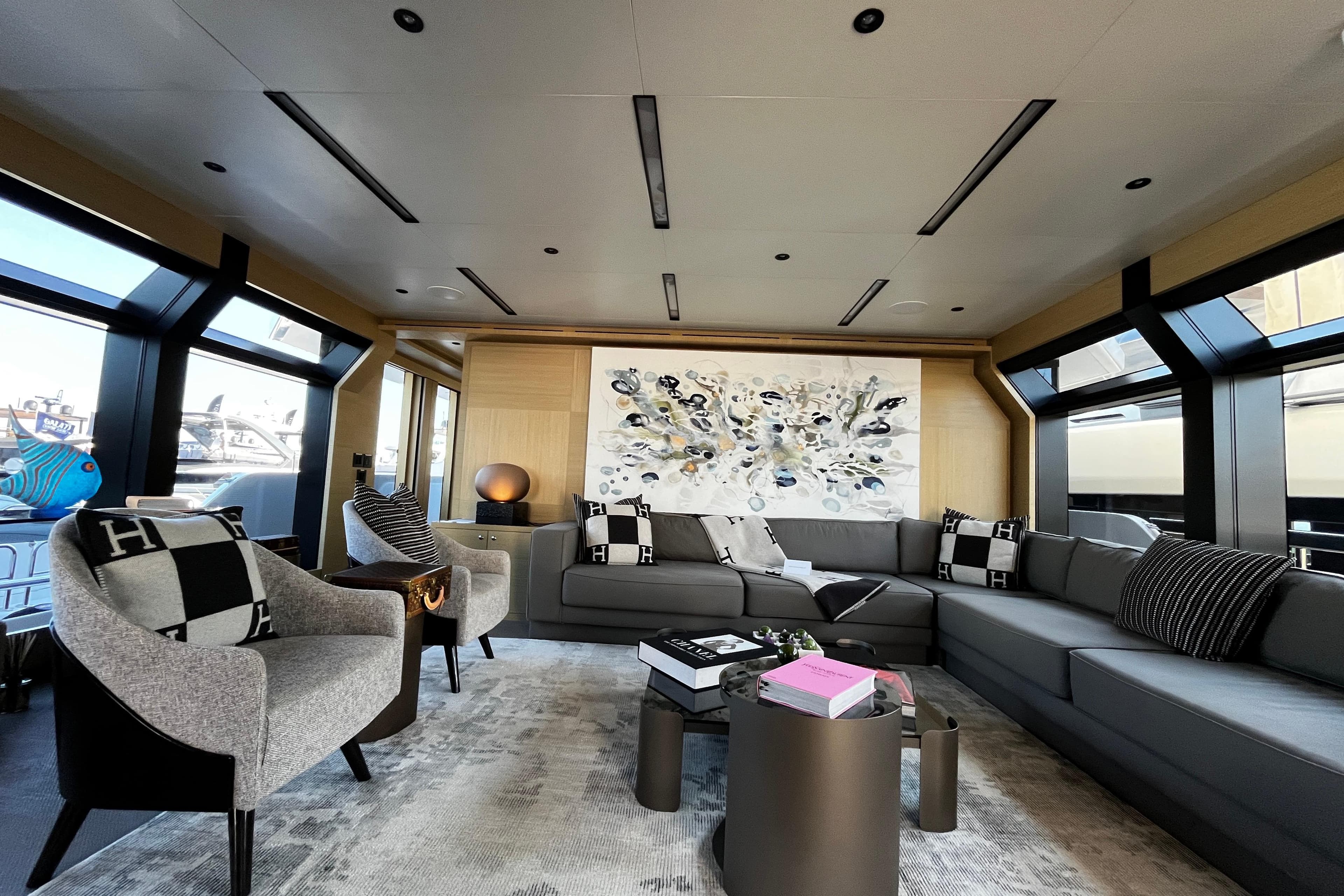 Luxurious yacht interior with modern decor, featuring a large sectional sofa and abstract wall art.