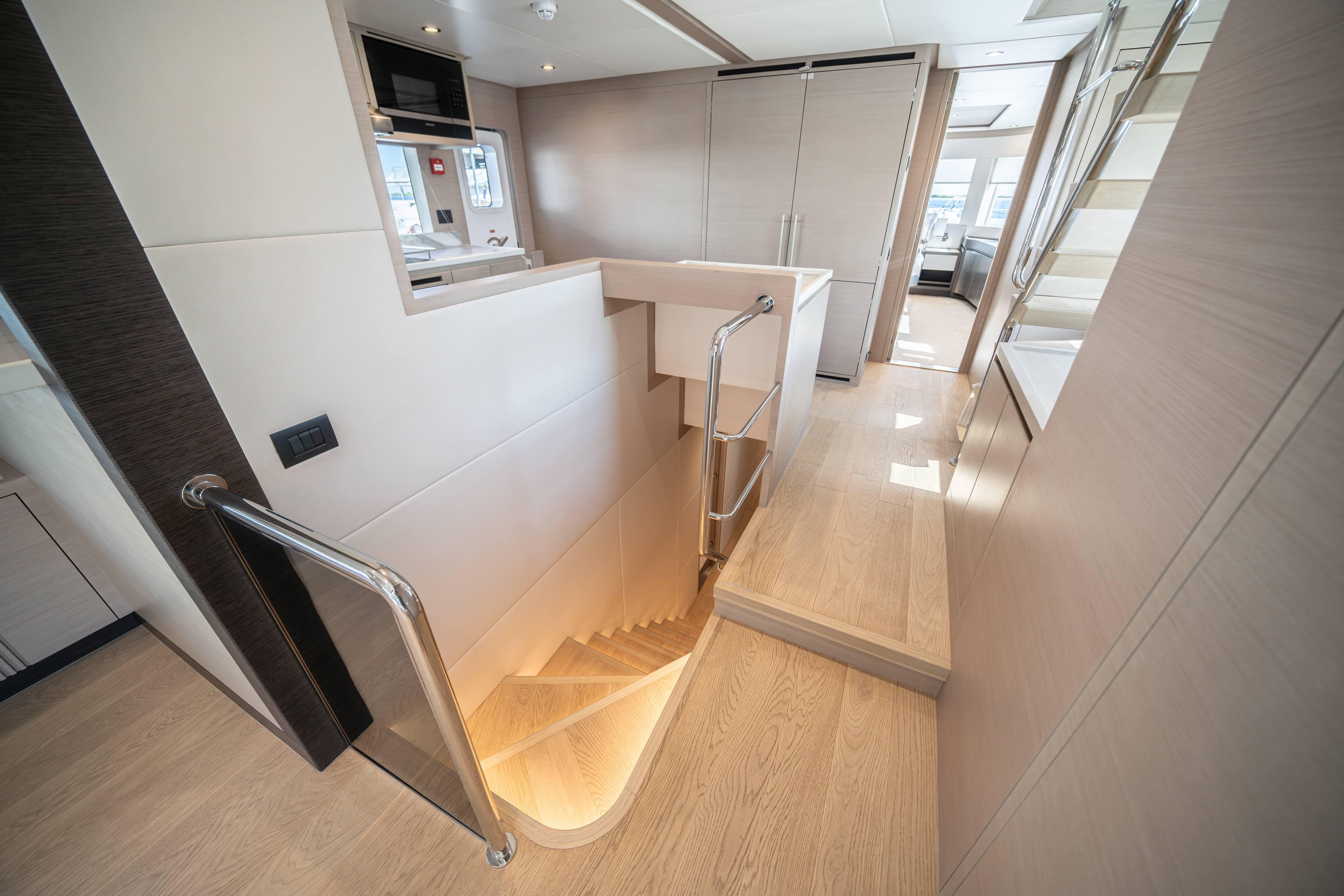 Luxurious interior of 2024 Nomad 75 SUV yacht with modern staircase and sleek design.