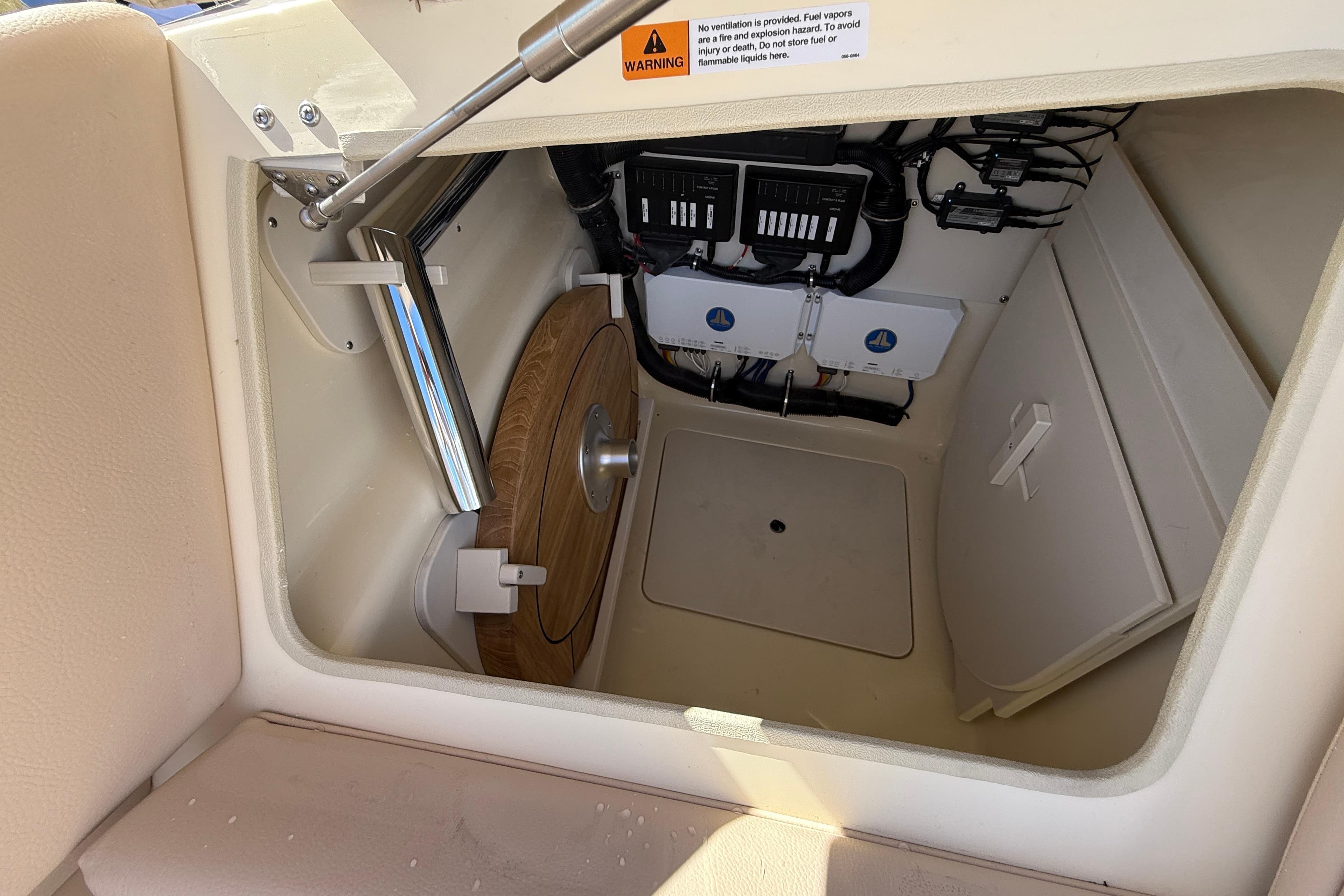 2026 Chris-Craft Launch 31 GT storage compartment with electrical components and wooden panel.