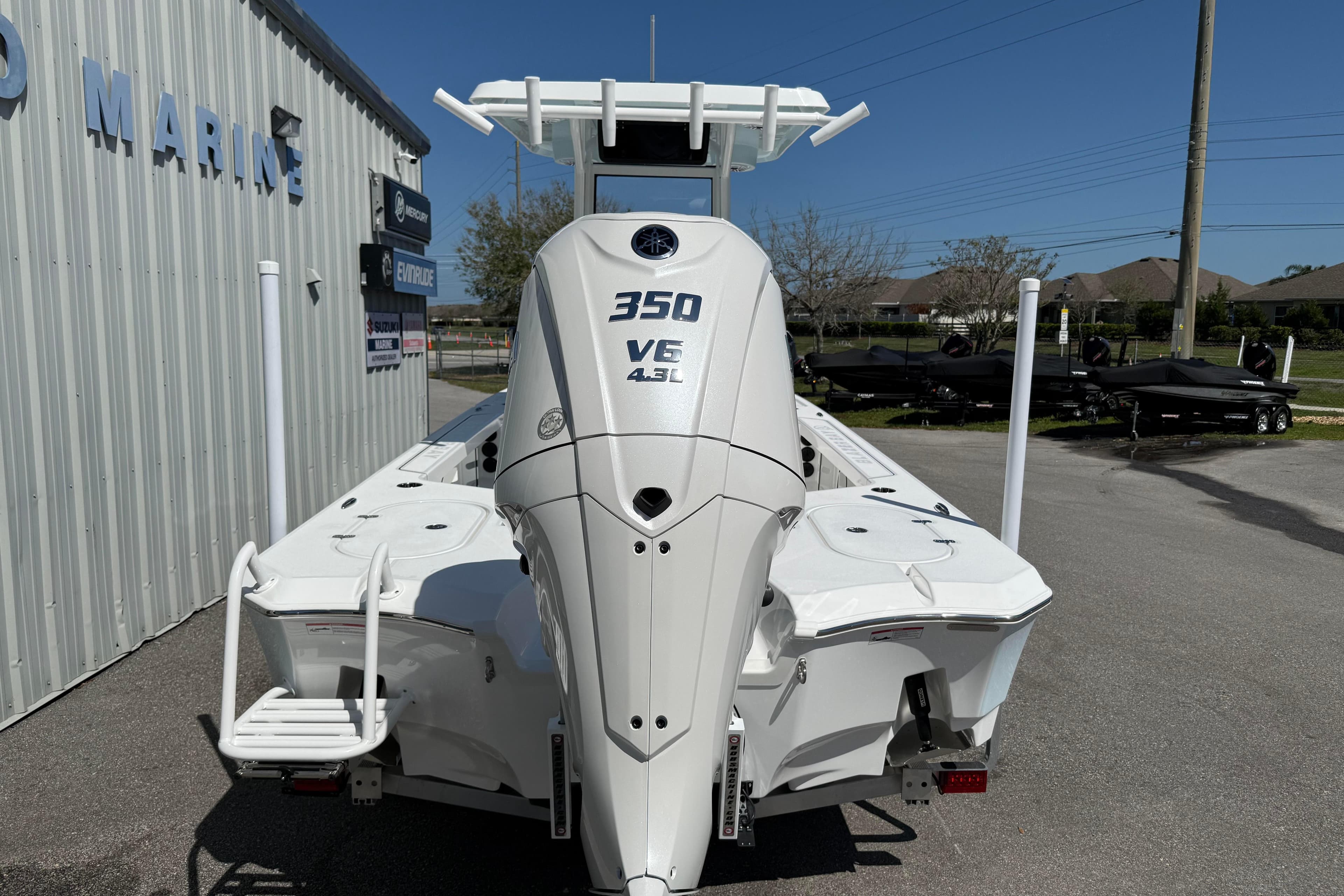 2026 Blazer 2550 GTS boat with 350 VE 4.3L engine, parked outside a marine shop.