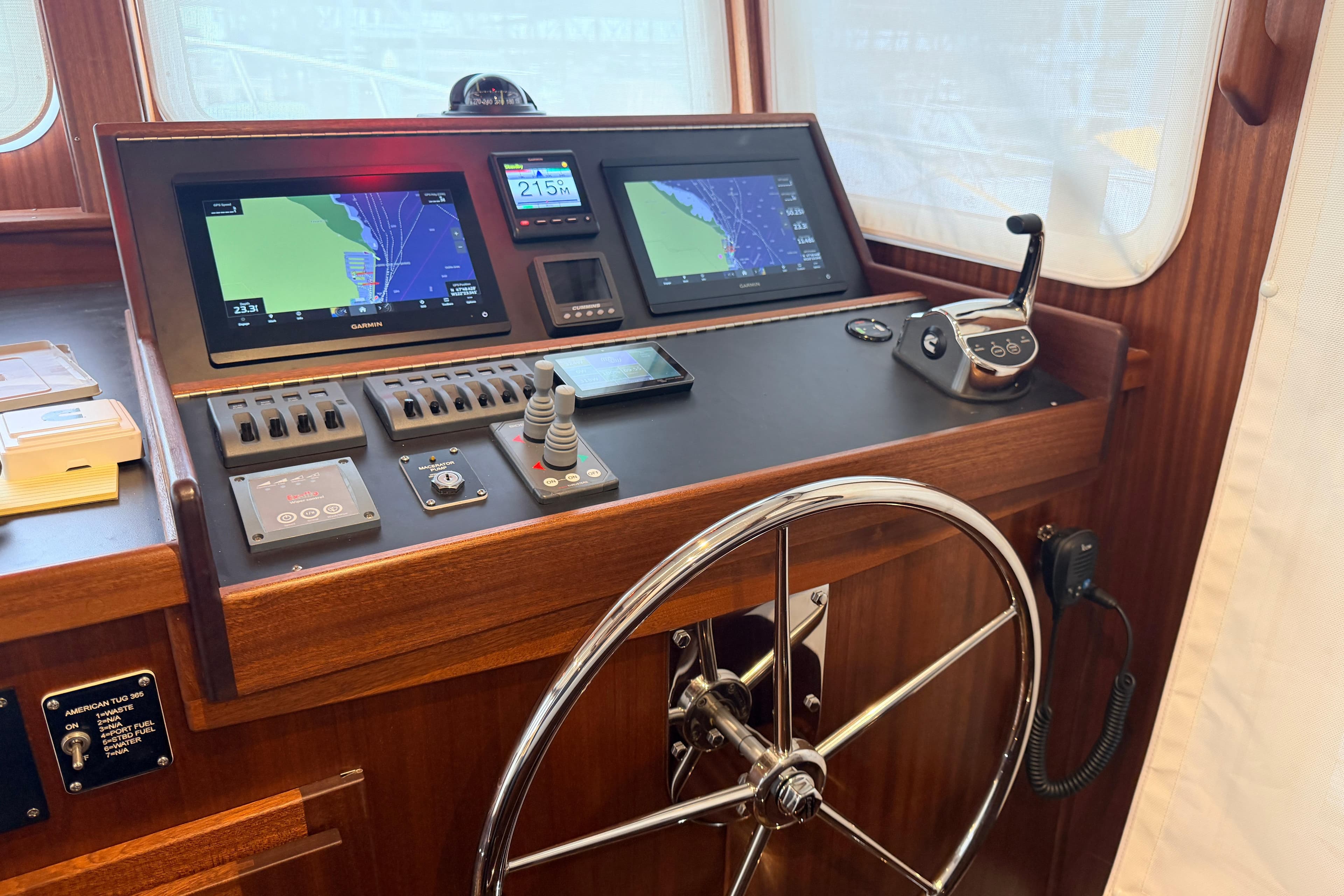 Pilothouse of 2022 American Tug 365 with navigation screens and steering wheel.