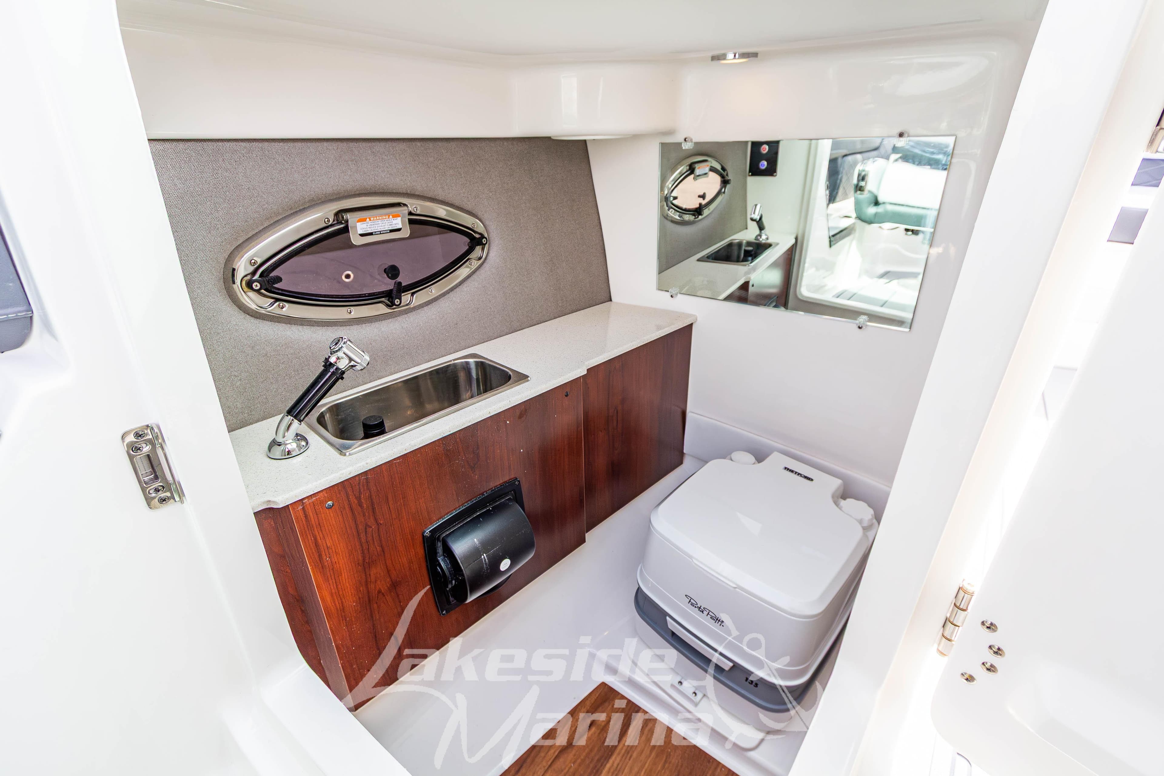 2026 Chaparral SSX 6 boat interior with sink, mirror, and portable toilet.
