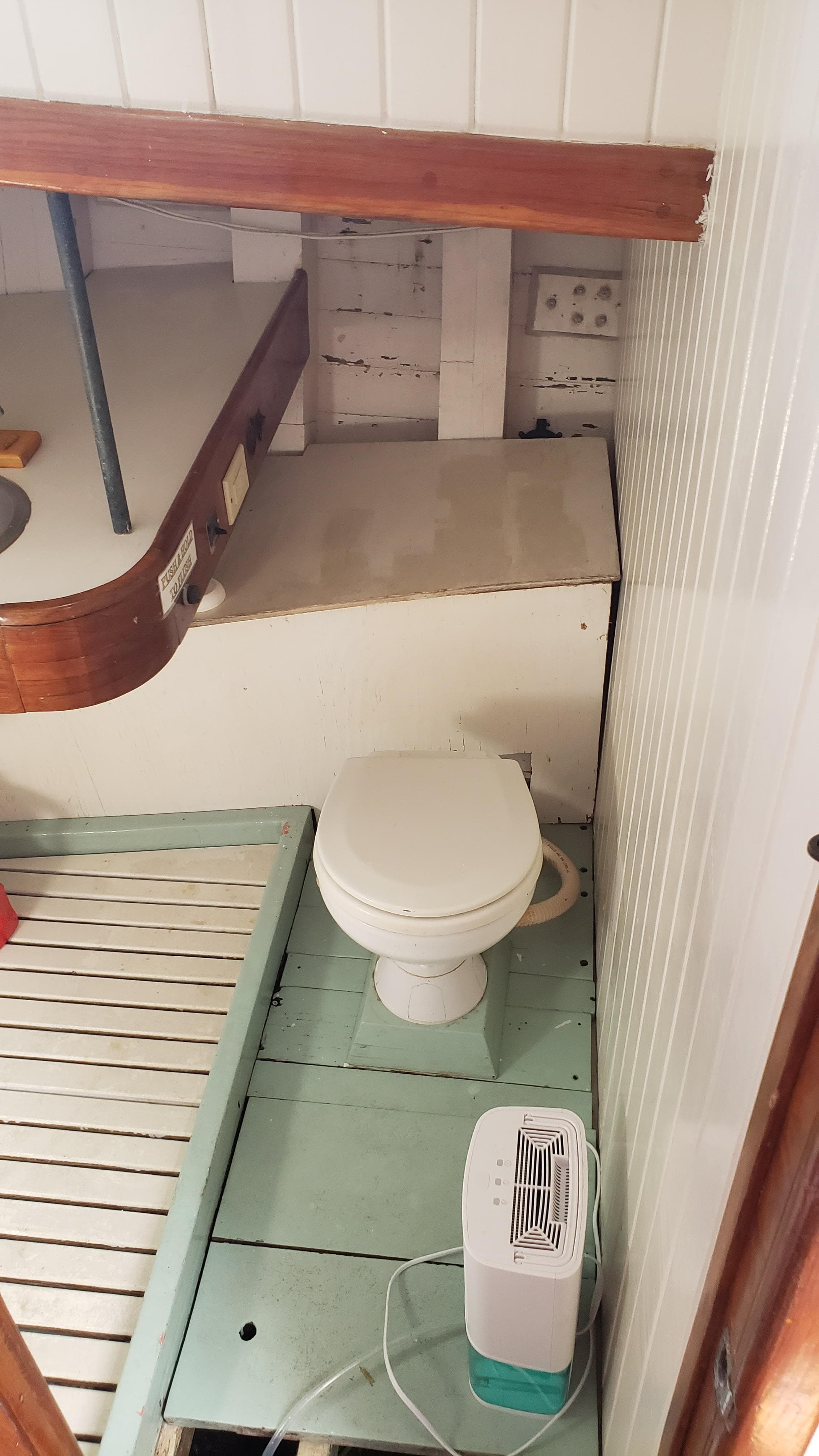 Compact bathroom on a 1996 Custom Biloxi Schooner with toilet and small heater.