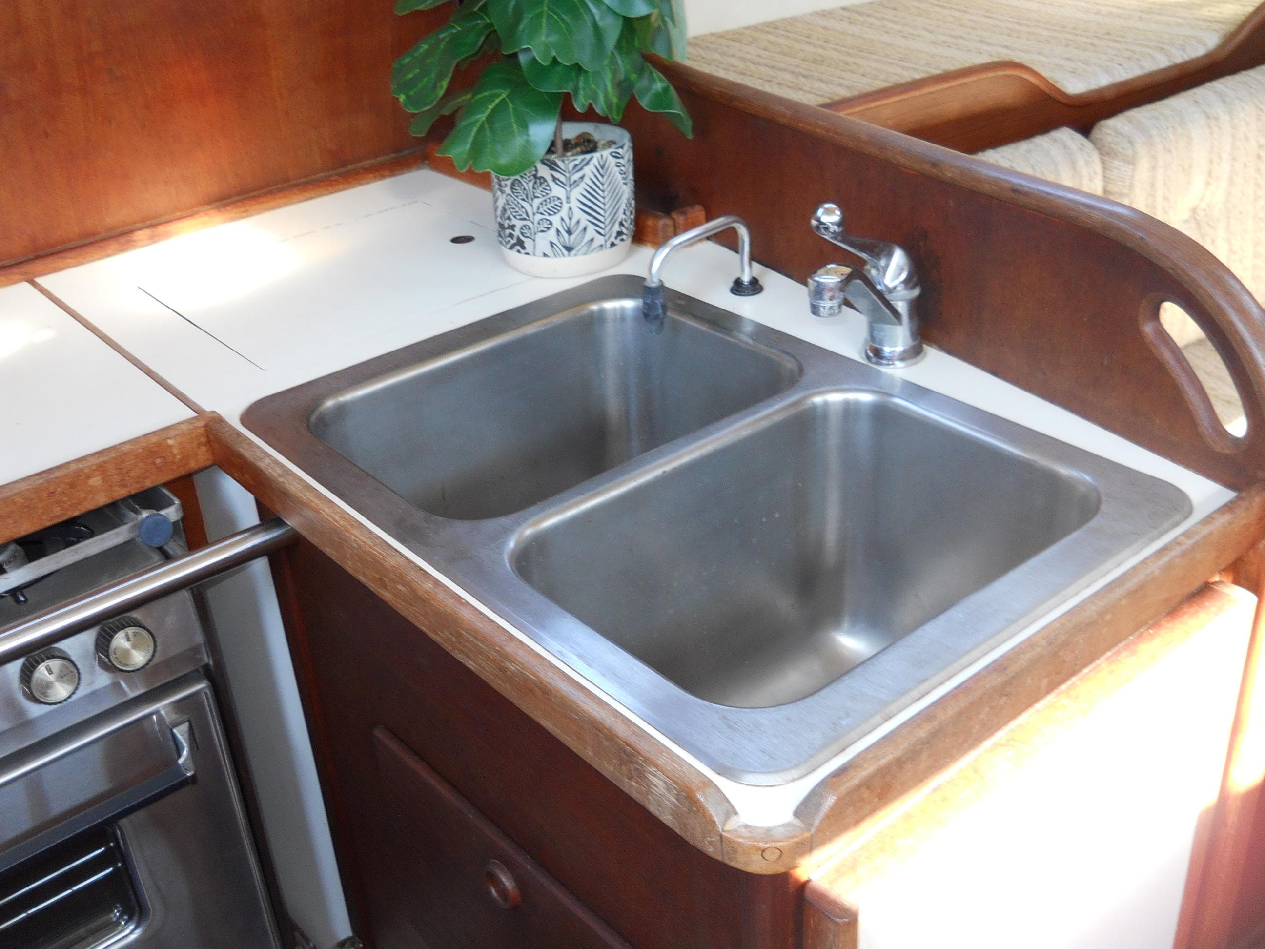 Double sink in a 1985 Sabre 38 MK I yacht kitchen with plant decor.