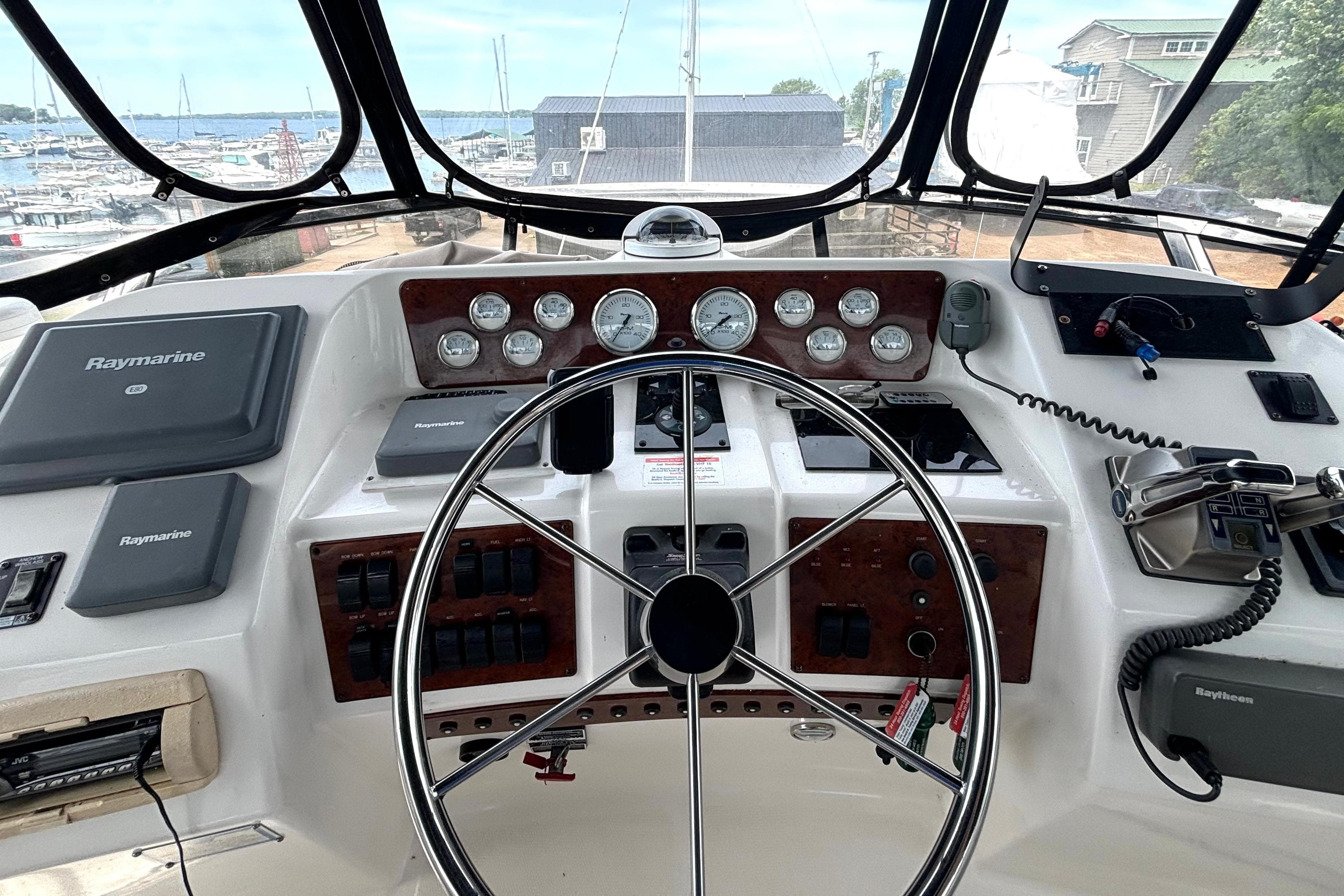 1999 Silverton 453 Motor Yacht helm with Raymarine navigation, gauges, and steering wheel.