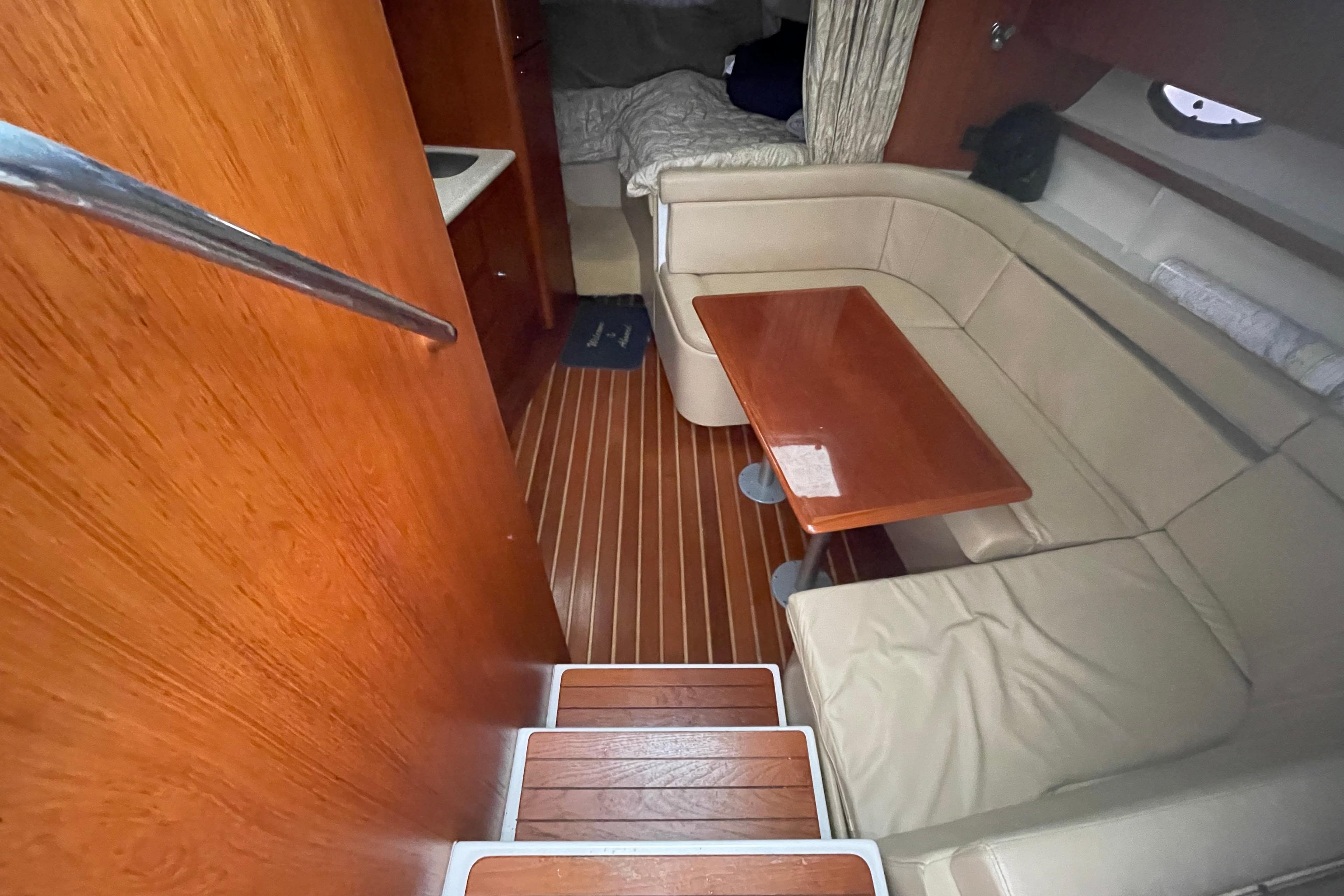 2003 Tiara Yachts 3100 Open interior with wooden flooring and beige seating area.