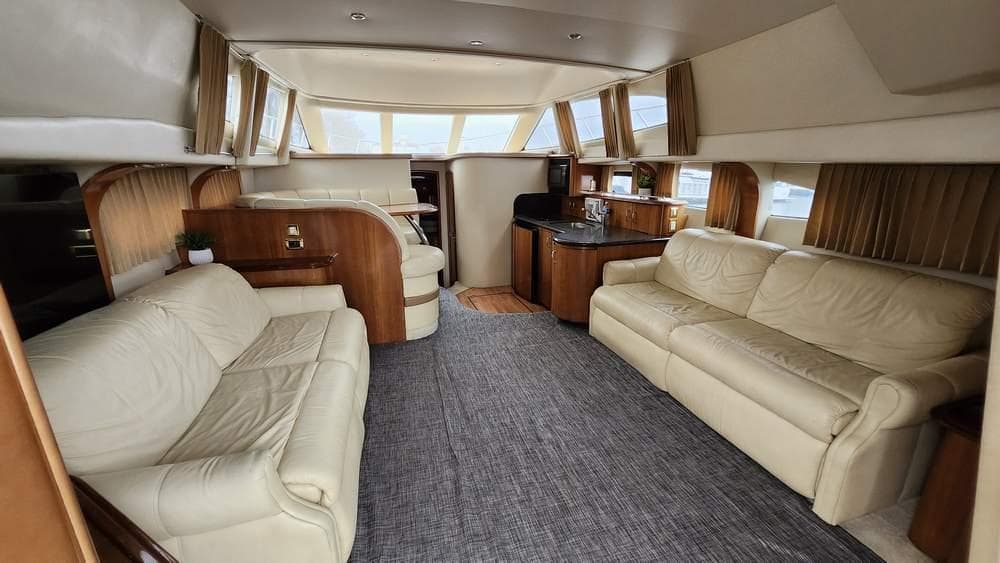 Luxurious interior of 2005 Carver 420 Mariner yacht with leather seating and wood accents.