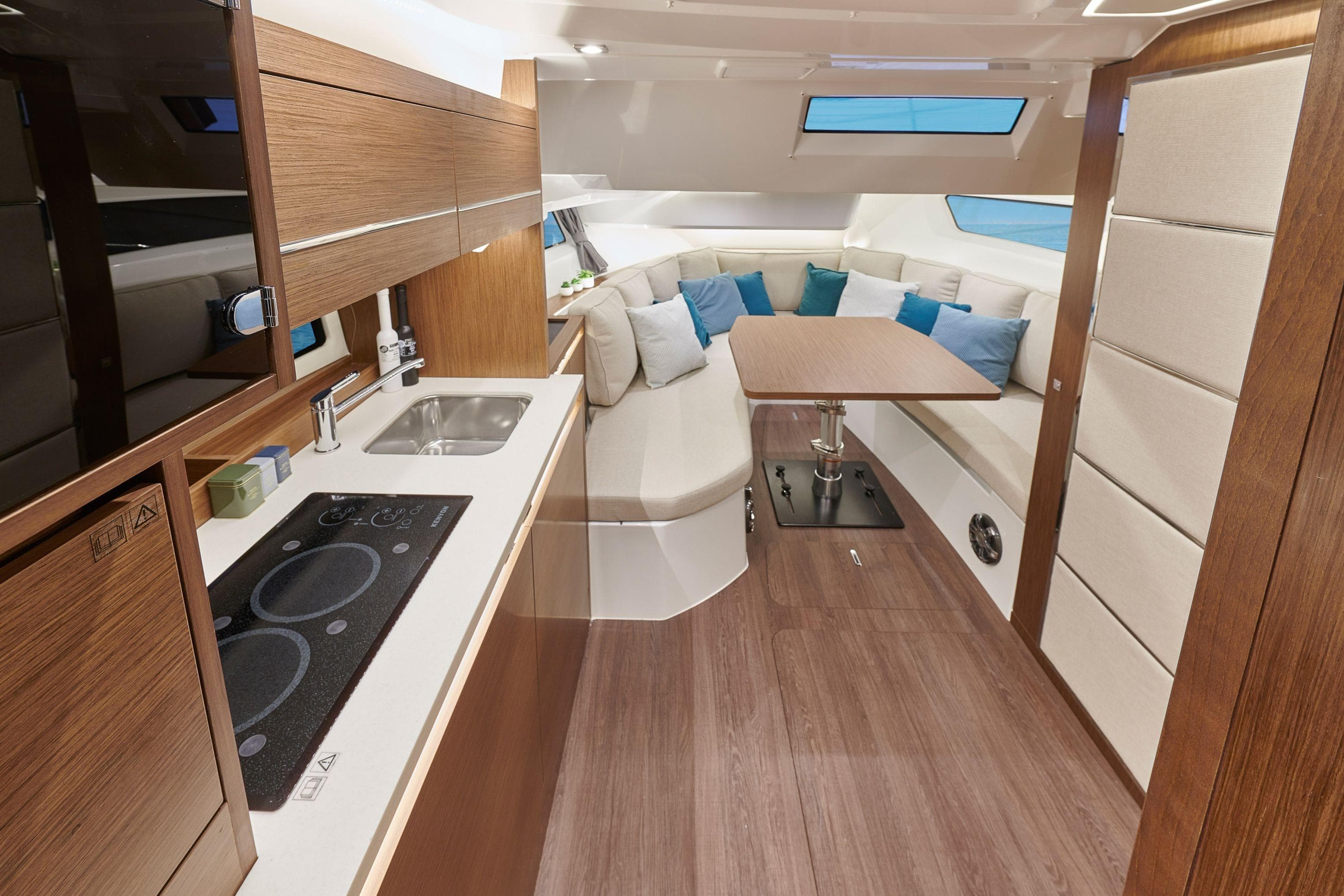 Luxurious interior of 2026 Jeanneau Leader 12.5 WA yacht with modern kitchen and seating area.