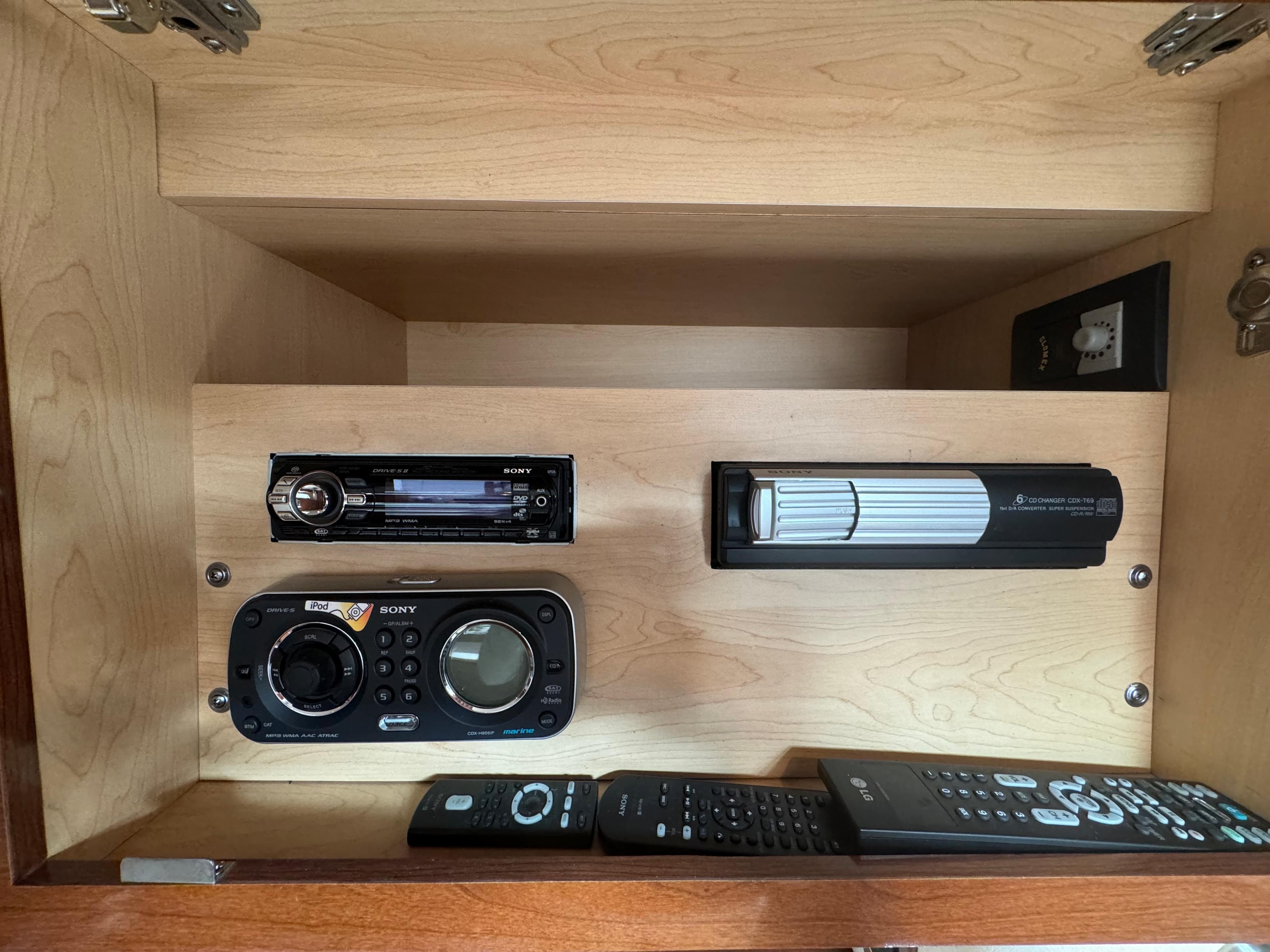 Cabinet with audio system and remotes in 2009 Sea Ray 350 Sundancer boat.