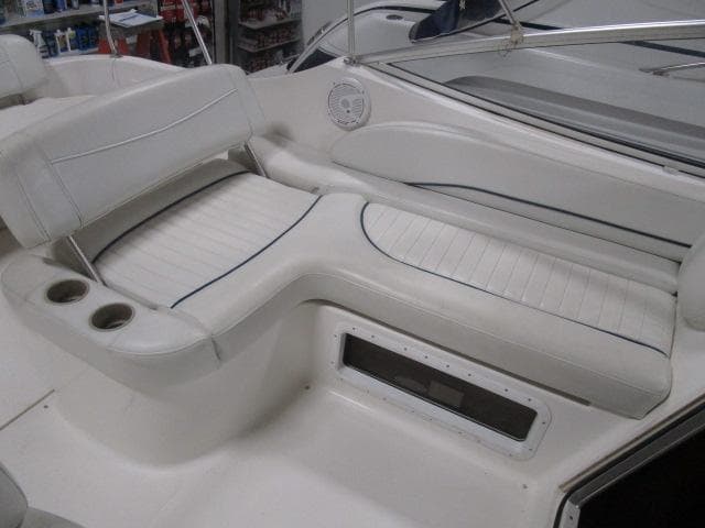 2002 Bayliner 2655 Ciera Sunbridge interior seating with cup holders and speaker.