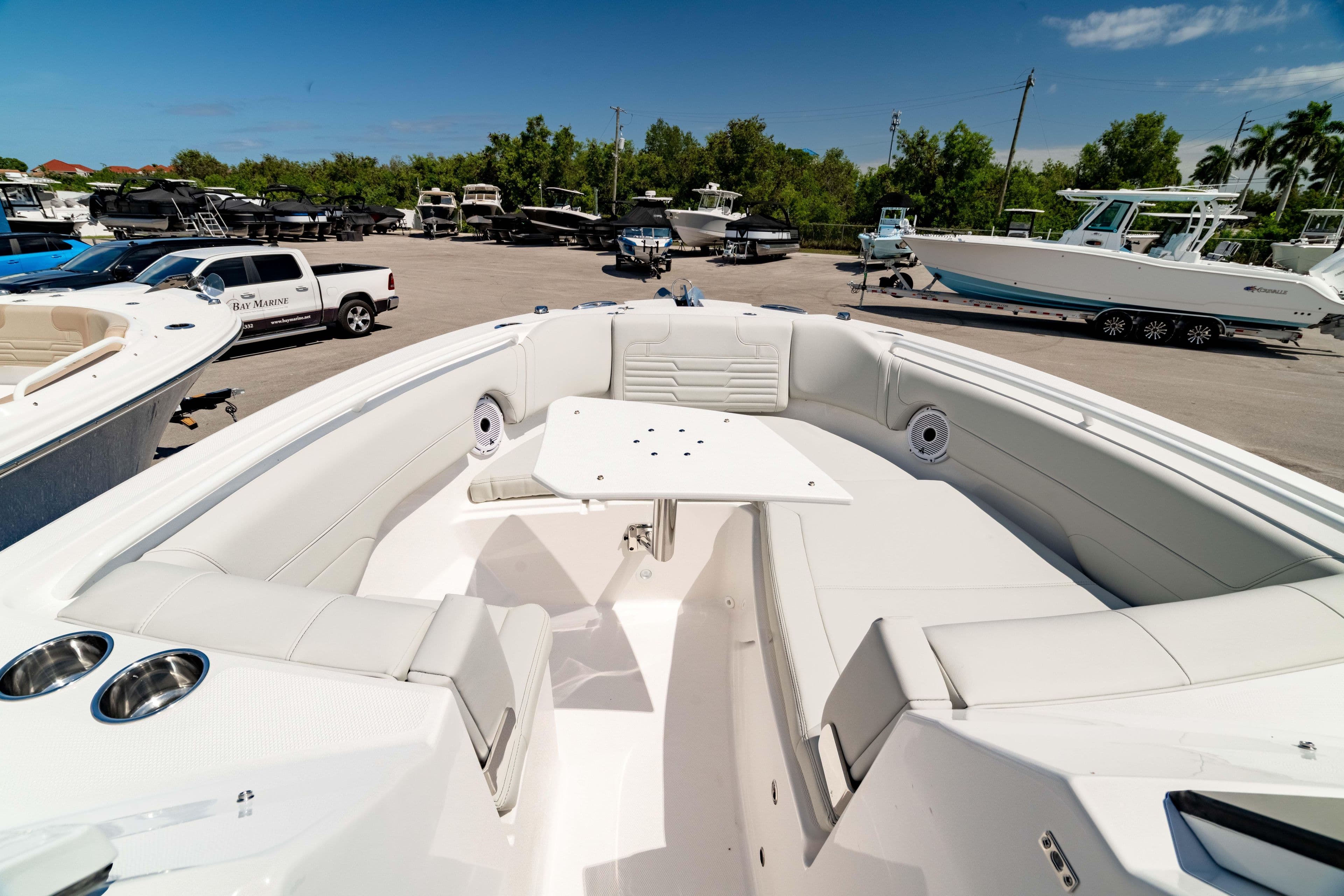 2026 Edgewater 262CX Crossover boat interior with seating and table, parked in a marina.