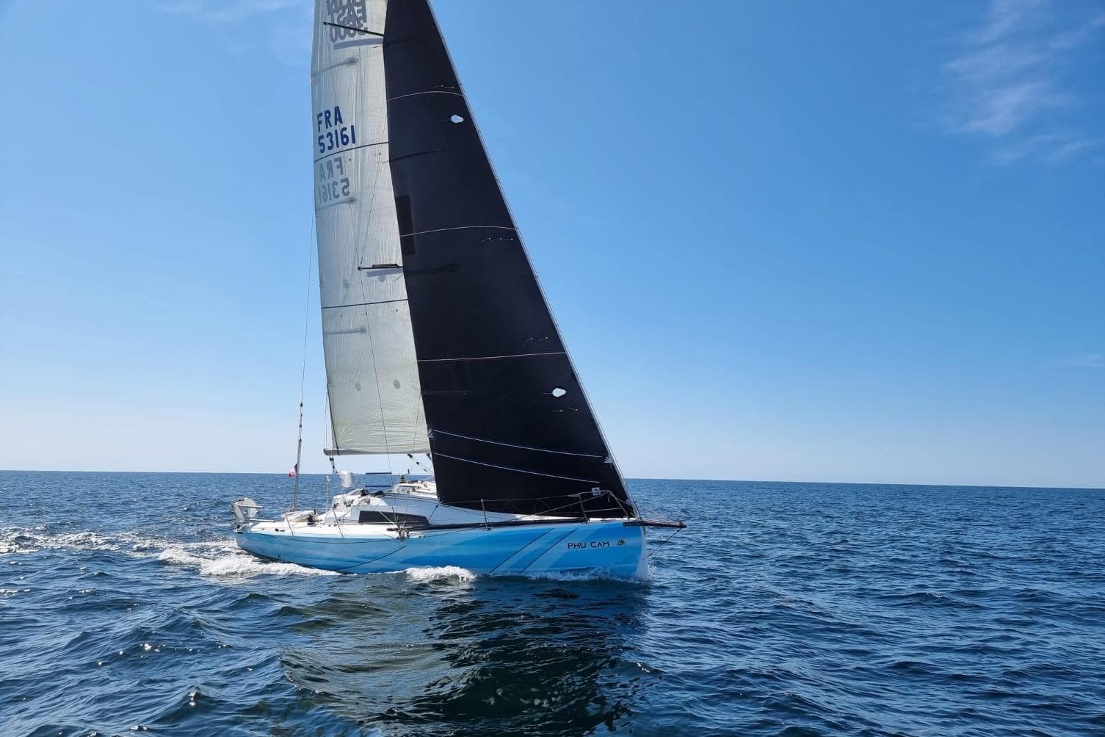 2019 Jeanneau Sun Fast 3600 sailing on open sea under clear blue sky.
