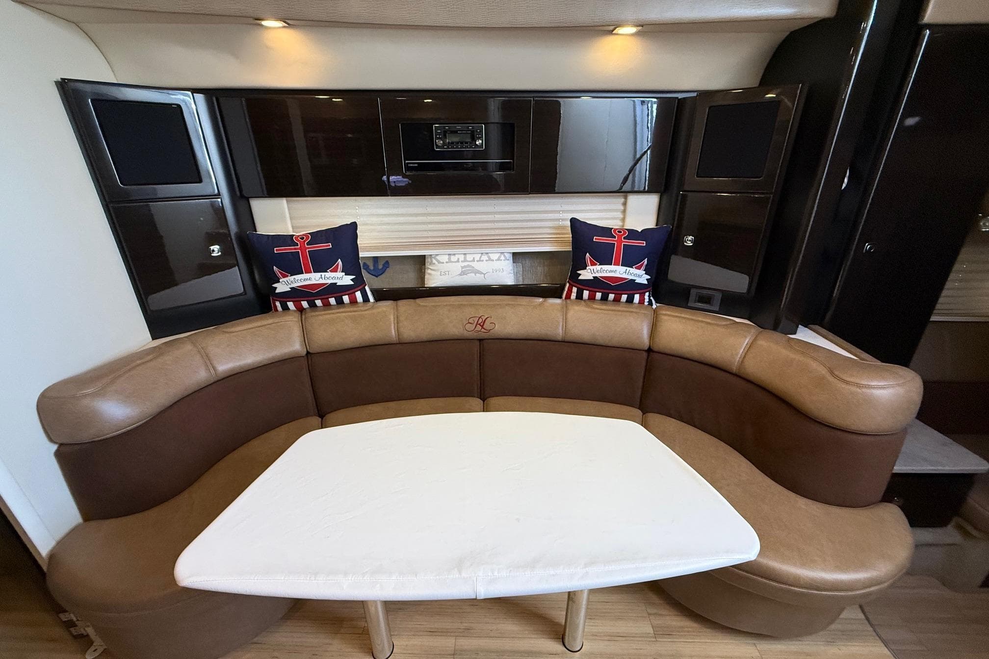 Interior of 2015 Formula 37 Performance Cruiser with curved seating and nautical decor.